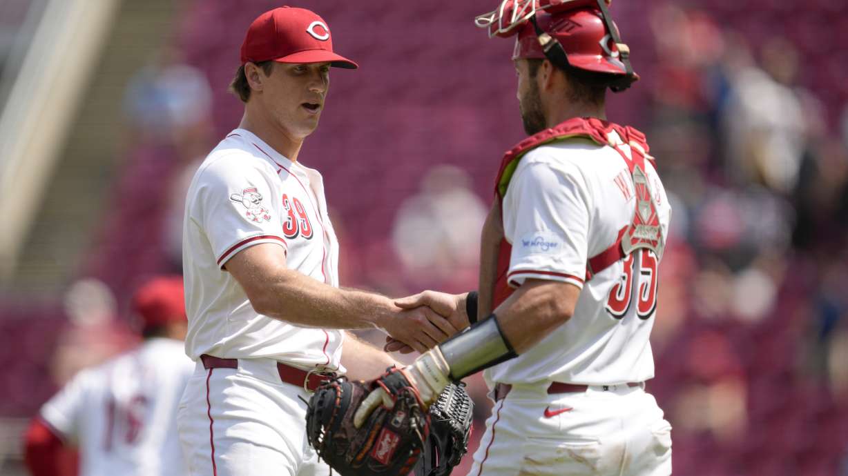 Cincinnati Reds' Lucas Sims, left, celebrates with Austin Wynns, right, after their victory over the Colorado Rockies in a baseball game, Thursday, July 11, 2024, in Cincinnati.