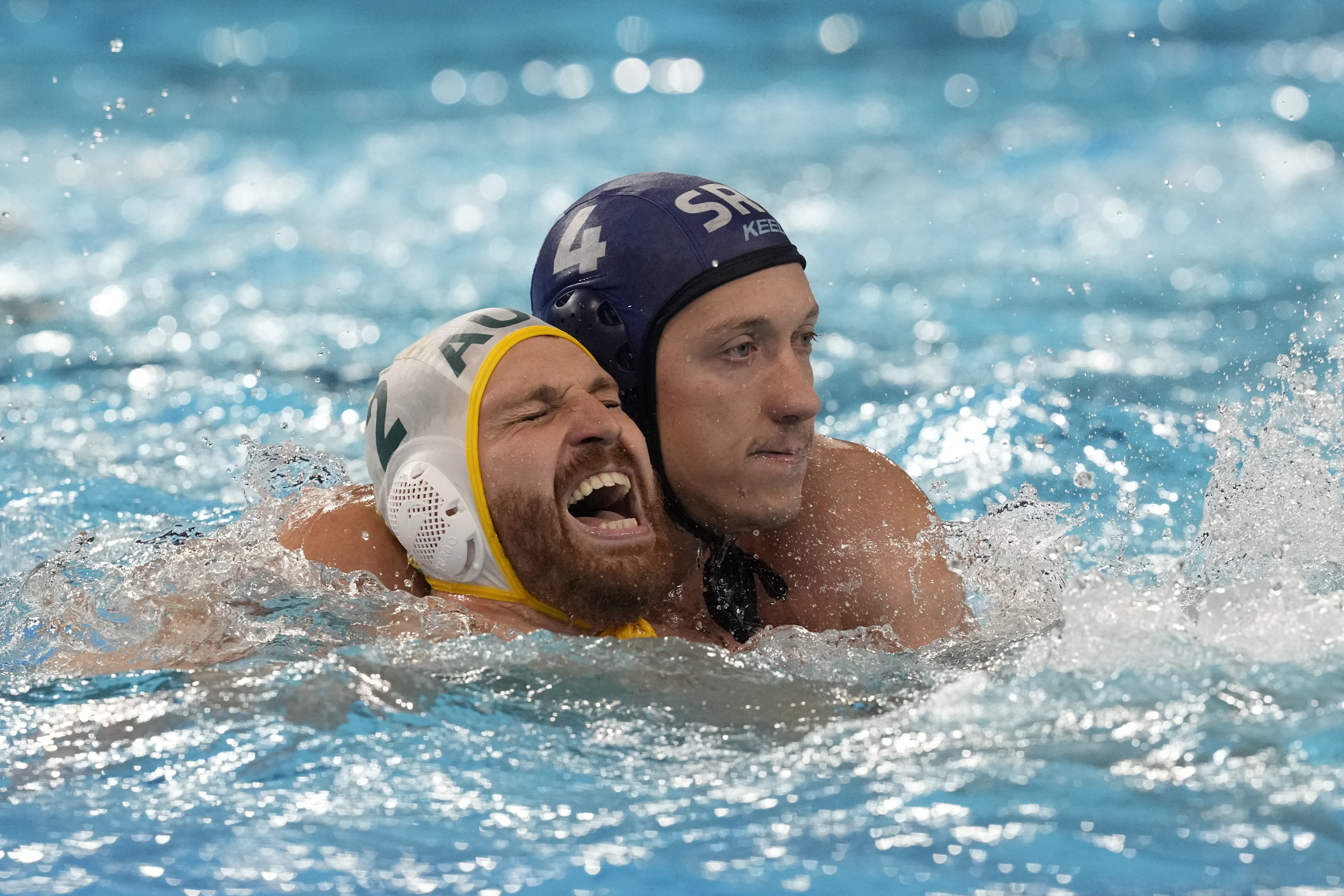 FILE - Australia's Angus Lambie, left, and Serbia's Sava Randelovic, right, battle for position during a men's water polo Group B preliminary match between Australia and Serbia at the 2024 Summer Olympics, Tuesday, July 30, 2024, in Saint-Denis, France. The most violent area of the pool during the Olympic water polo tournaments is the one right in front of the goal, where centers are consistently pummeled by defenders draped all over their backs. 