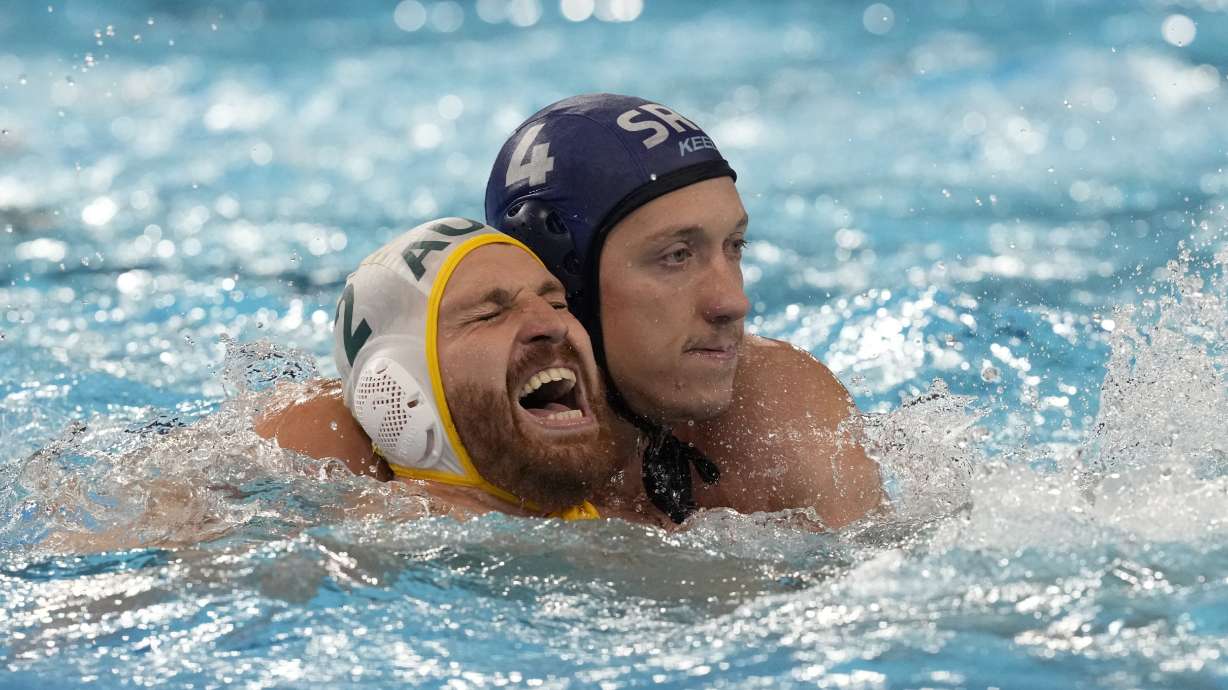 FILE - Australia's Angus Lambie, left, and Serbia's Sava Randelovic, right, battle for position during a men's water polo Group B preliminary match between Australia and Serbia at the 2024 Summer Olympics, Tuesday, July 30, 2024, in Saint-Denis, France. The most violent area of the pool during the Olympic water polo tournaments is the one right in front of the goal, where centers are consistently pummeled by defenders draped all over their backs.