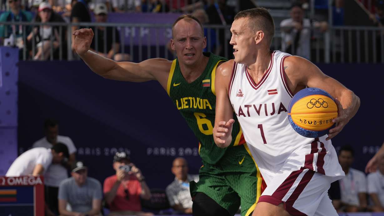 Nauris Miezis of Latvia drives past Gintautas Matulis of Lithuania in the men's 3x3 basketball pool round match between Latvia and Lithuania at the 2024 Summer Olympics, Tuesday, July 30, 2024, in Paris, France.