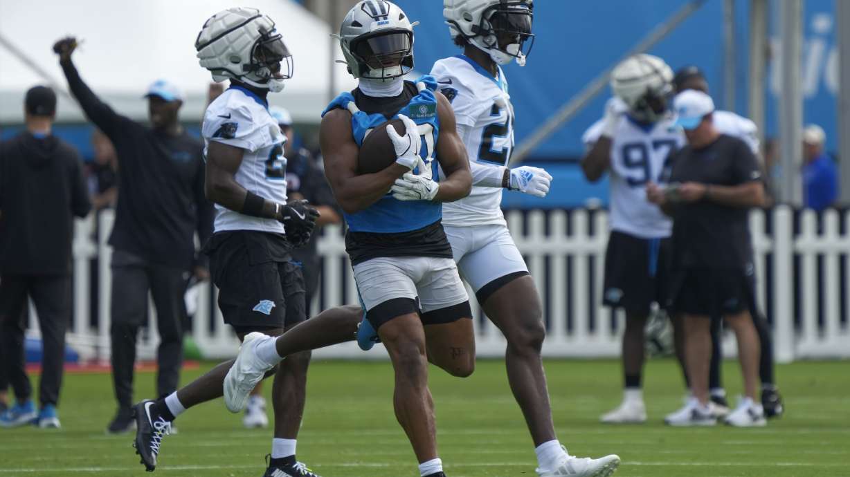 Carolina Panthers running back Chuba Hubbard, center, runs a drill during the NFL football team's training camp in Charlotte, N.C., Wednesday, July 24, 2024.