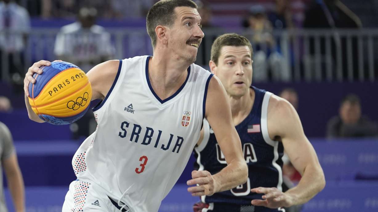 Strahinja Stojacic of Serbia drives past Jimmer Fredette of the United States in the men's 3x3 basketball pool round match between Serbia and the United States at the 2024 Summer Olympics, Tuesday, July 30, 2024, in Paris, France.