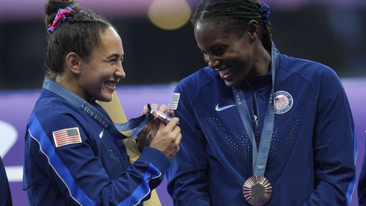United States' Alex Sedrick, left admires her bronze medal for the Rugby Sevens as she takes part with her fellow team members in the presentation ceremony at the 2024 Summer Olympics, in the Stade de France, in Saint-Denis, France, Tuesday, July 30, 2024.