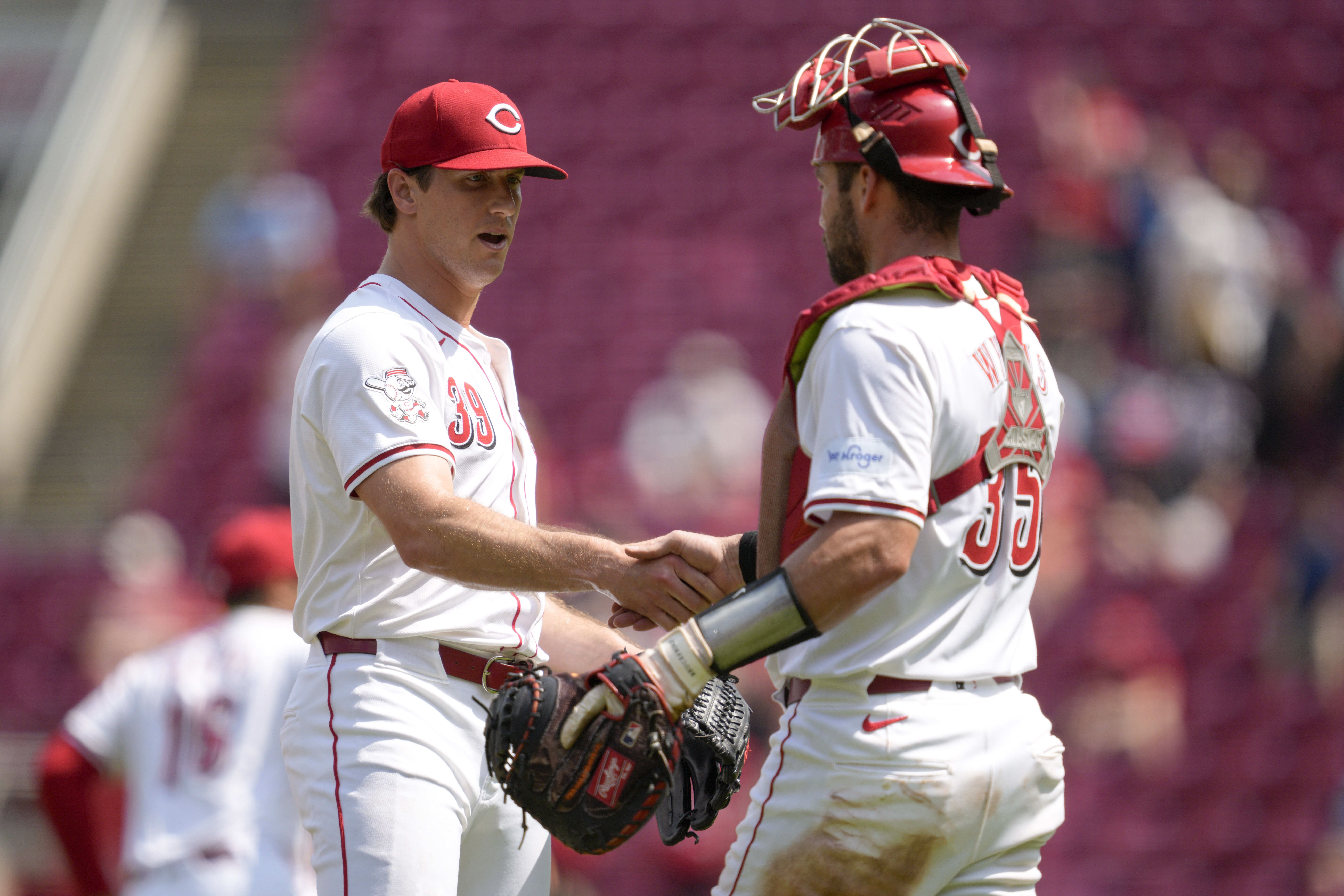 Cincinnati Reds' Lucas Sims, left, celebrates with Austin Wynns, right, after their victory over the Colorado Rockies in a baseball game, Thursday, July 11, 2024, in Cincinnati. 