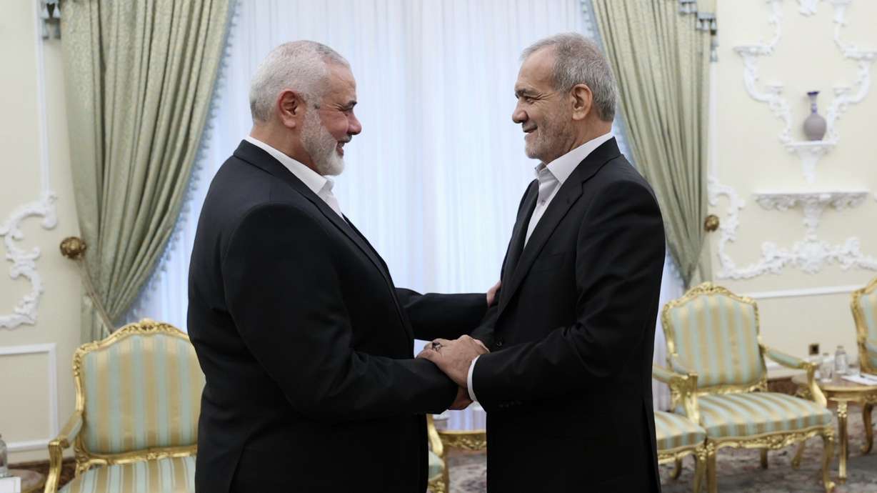 In this photo released by the Iranian Presidency Office, President Masoud Pezeshkian, right, shakes hands with Hamas chief Ismail Haniyeh at the start of their meeting at the president's office in Tehran, Iran, Tuesday.