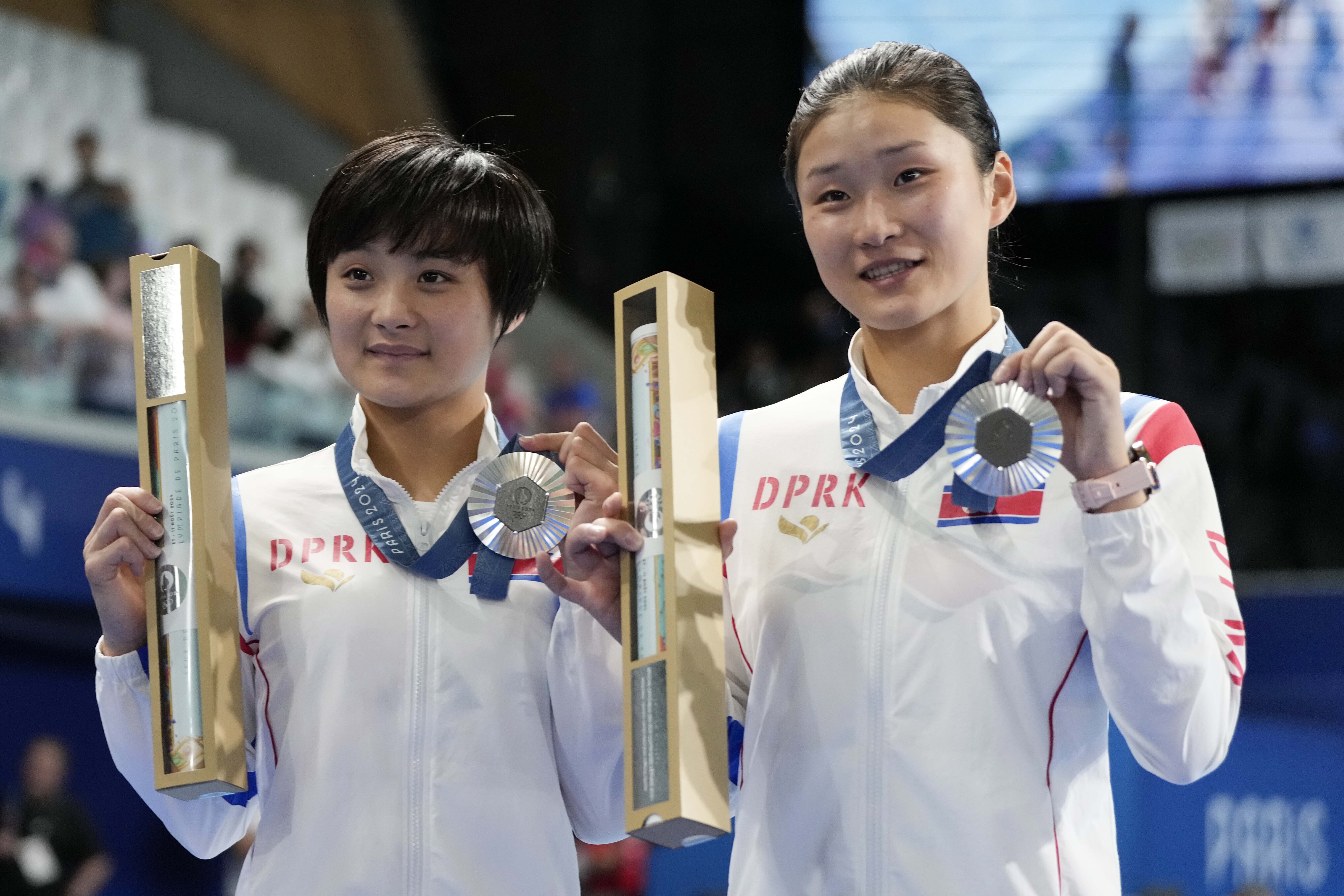 North Korea's Jo Jin Mi and Kim Mi Rae pose with their silver medal on the podium of the women's synchronised 10m platform diving final at the 2024 Summer Olympics, Wednesday, July 31, 2024, in Saint-Denis, France. 