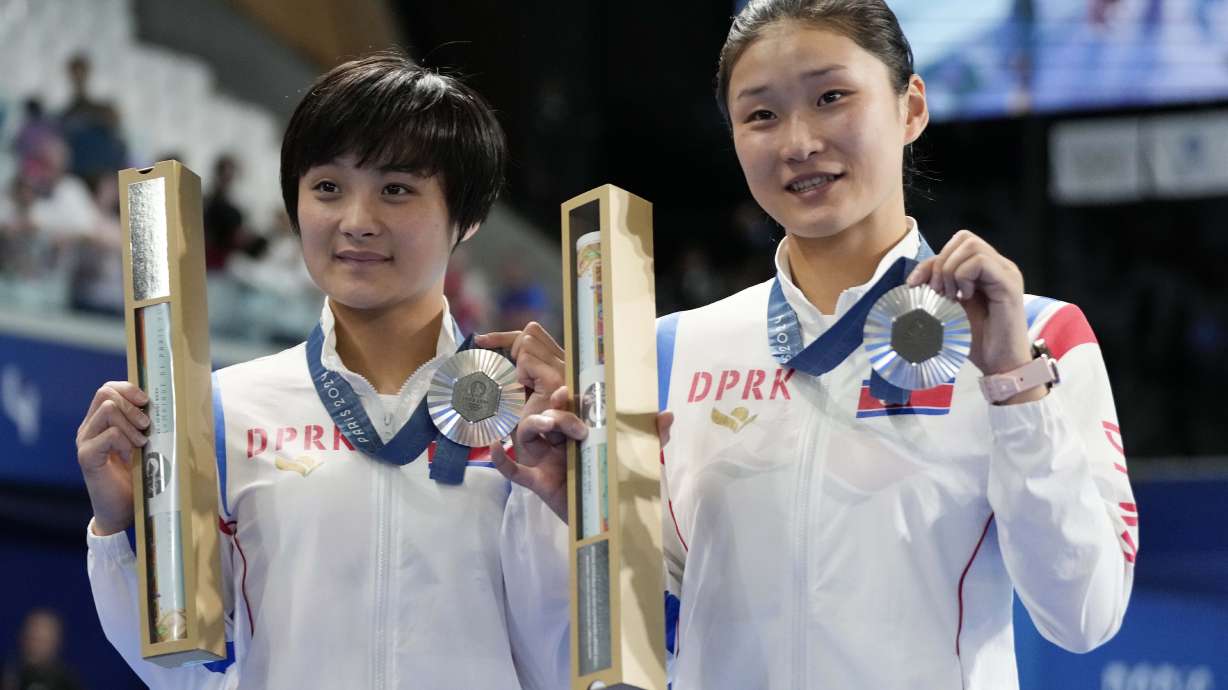 North Korea's Jo Jin Mi and Kim Mi Rae pose with their silver medal on the podium of the women's synchronised 10m platform diving final at the 2024 Summer Olympics, Wednesday, July 31, 2024, in Saint-Denis, France.