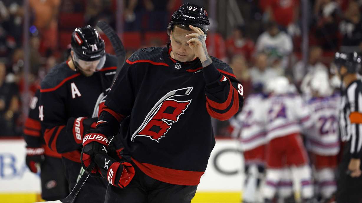 FILE- Carolina Hurricanes' Evgeny Kuznetsov (92) and Jaccob Slavin (74) skate off as New York Rangers celebrate in the background following Game 6 of an NHL hockey Stanley Cup second-round playoff series in Raleigh, N.C., Thursday, May 16, 2024. The Hurricanes have put Kuznetsov on unconditional waivers for the purpose of terminating his NHL contract. General manager Eric Tulsky said the two sides ultimately agreed this was the best course of action for the player and the team.