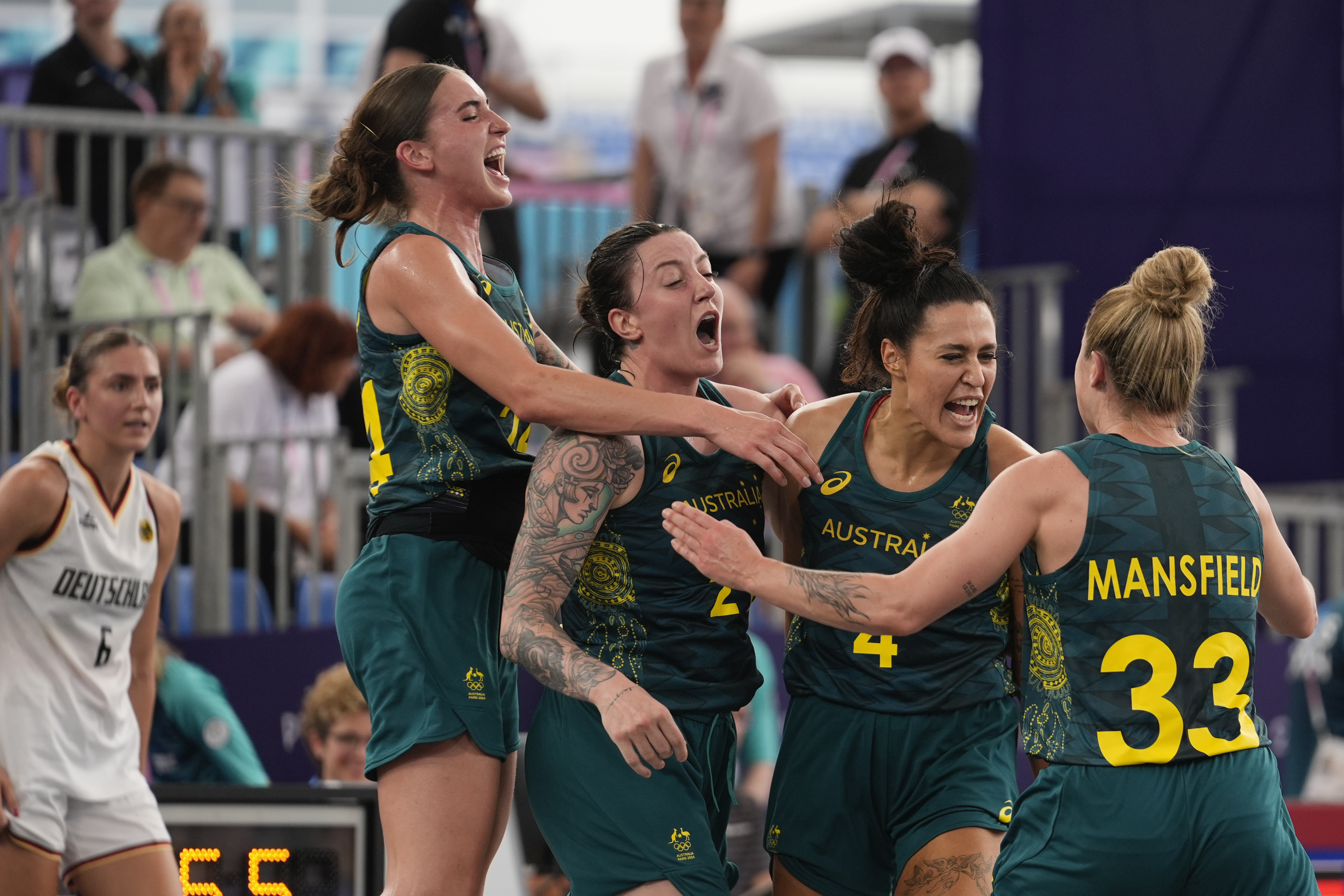 Australia's, from left, Anneli Maley, Marena Whittle, Alex Wilson and Lauren Mansfield celebrate their victory as Germany's Marie Reichert looks on, in the women's 3x3 basketball pool round match between Germany and Australia at the 2024 Summer Olympics, Wednesday, July 31, 2024, in Paris, France. 