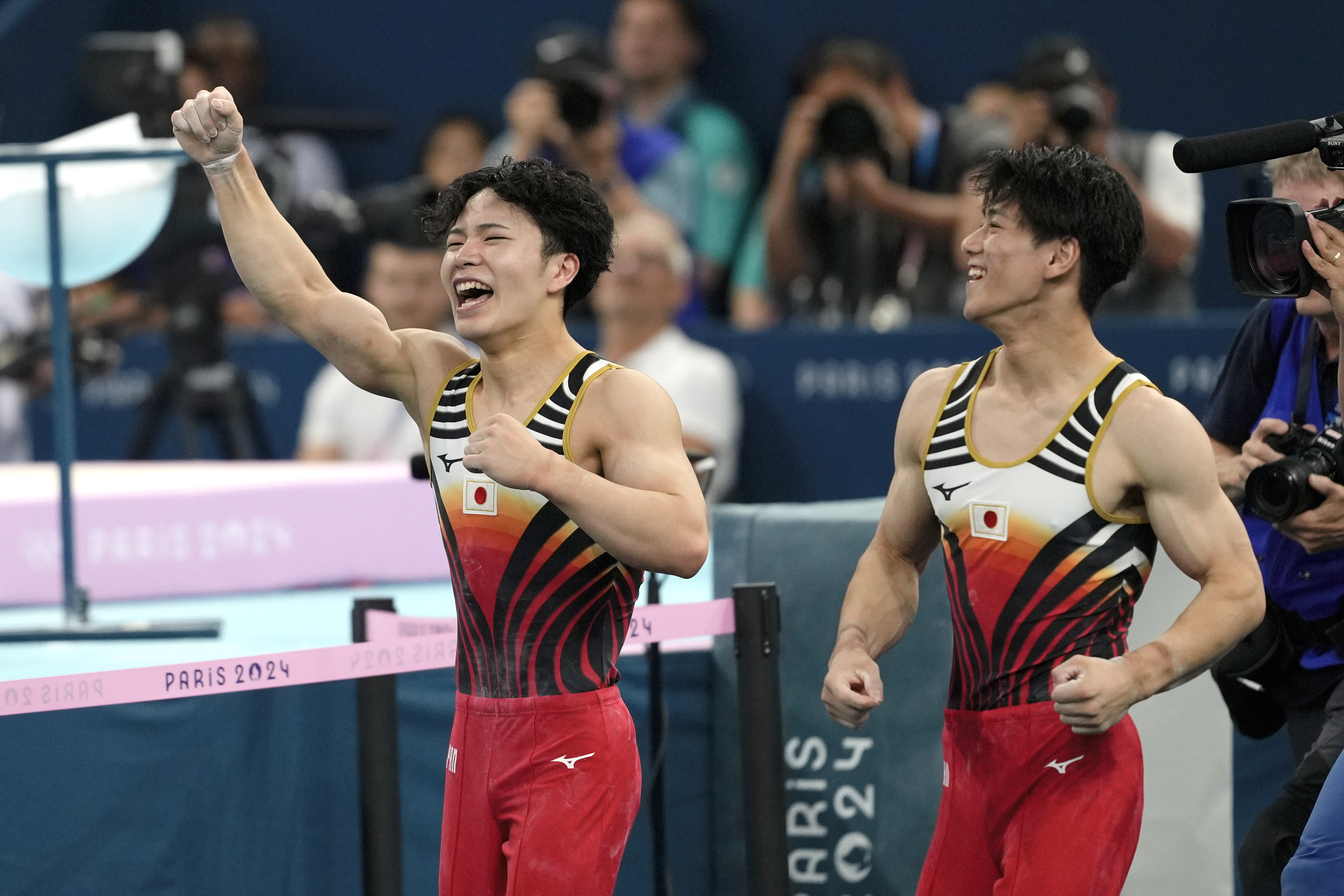 Shinnosuke Oka, left, and Daiki Hashimoto, of Japan, right, celebrate after Oka won the gold medal during the men's artistic gymnastics all-around finals in Bercy Arena at the 2024 Summer Olympics, Wednesday, July 31, 2024, in Paris, France. 