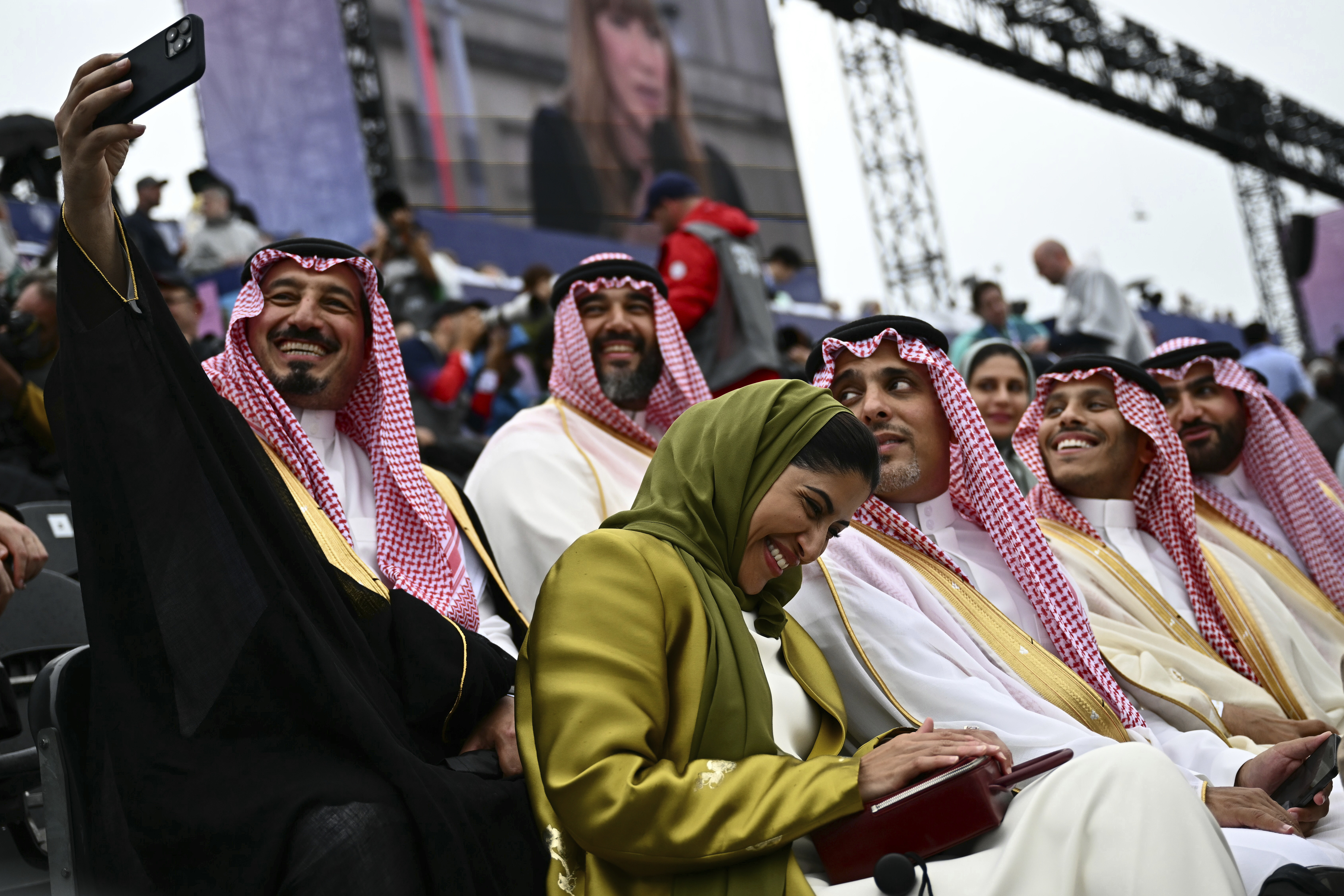 Attendees from Saudi Arabia take selfies ahead the opening ceremony for the 2024 Summer Olympics in Paris, France, Friday, July 26, 2024. 