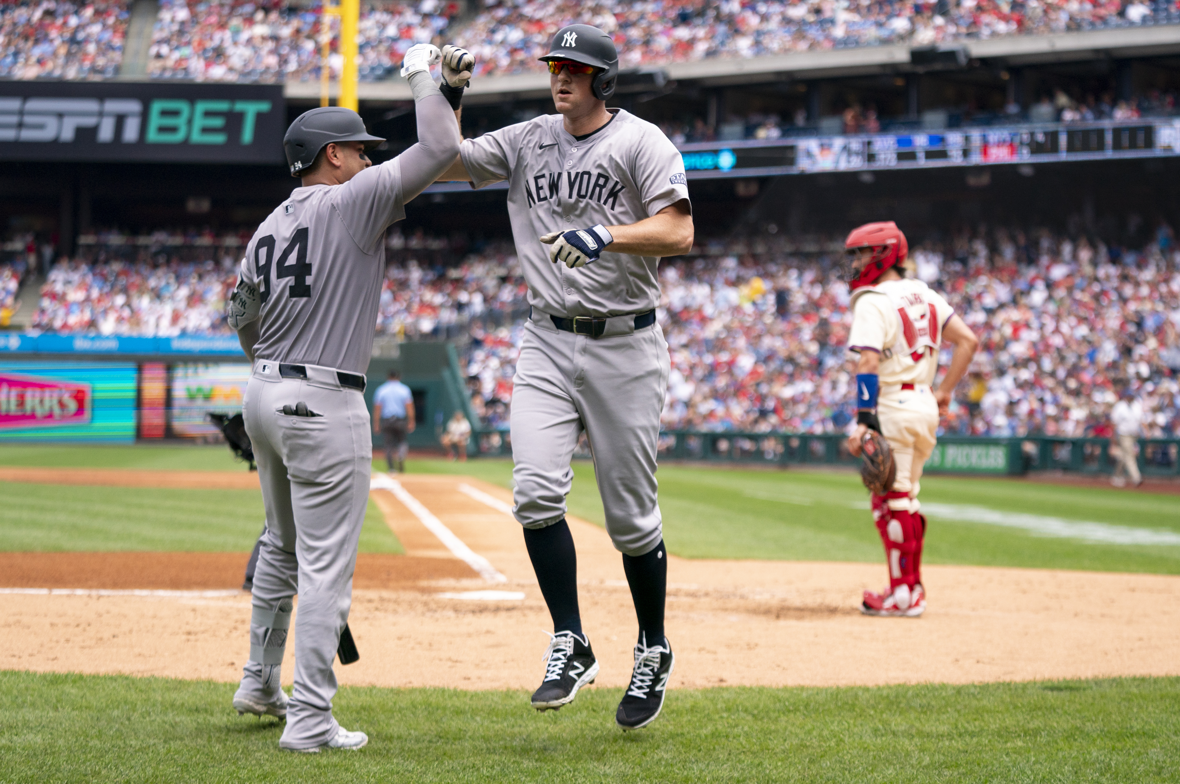 New York Yankees' DJ LeMahieu, center, celebrates his grand slam with Carlos Narvaez, left, as Philadelphia Phillies catcher Garrett Stubbs, right, looks on during the second inning of a baseball game, Wednesday, July 31, 2024, in Philadelphia. 