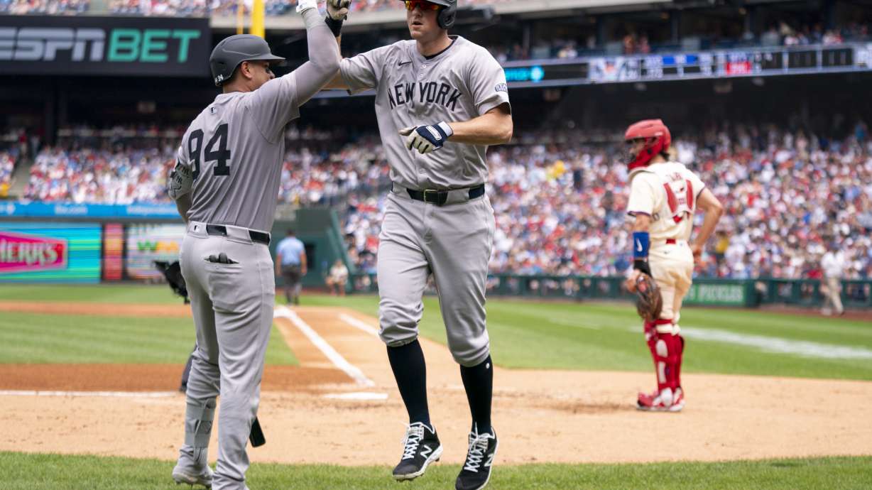 New York Yankees' DJ LeMahieu, center, celebrates his grand slam with Carlos Narvaez, left, as Philadelphia Phillies catcher Garrett Stubbs, right, looks on during the second inning of a baseball game, Wednesday, July 31, 2024, in Philadelphia.