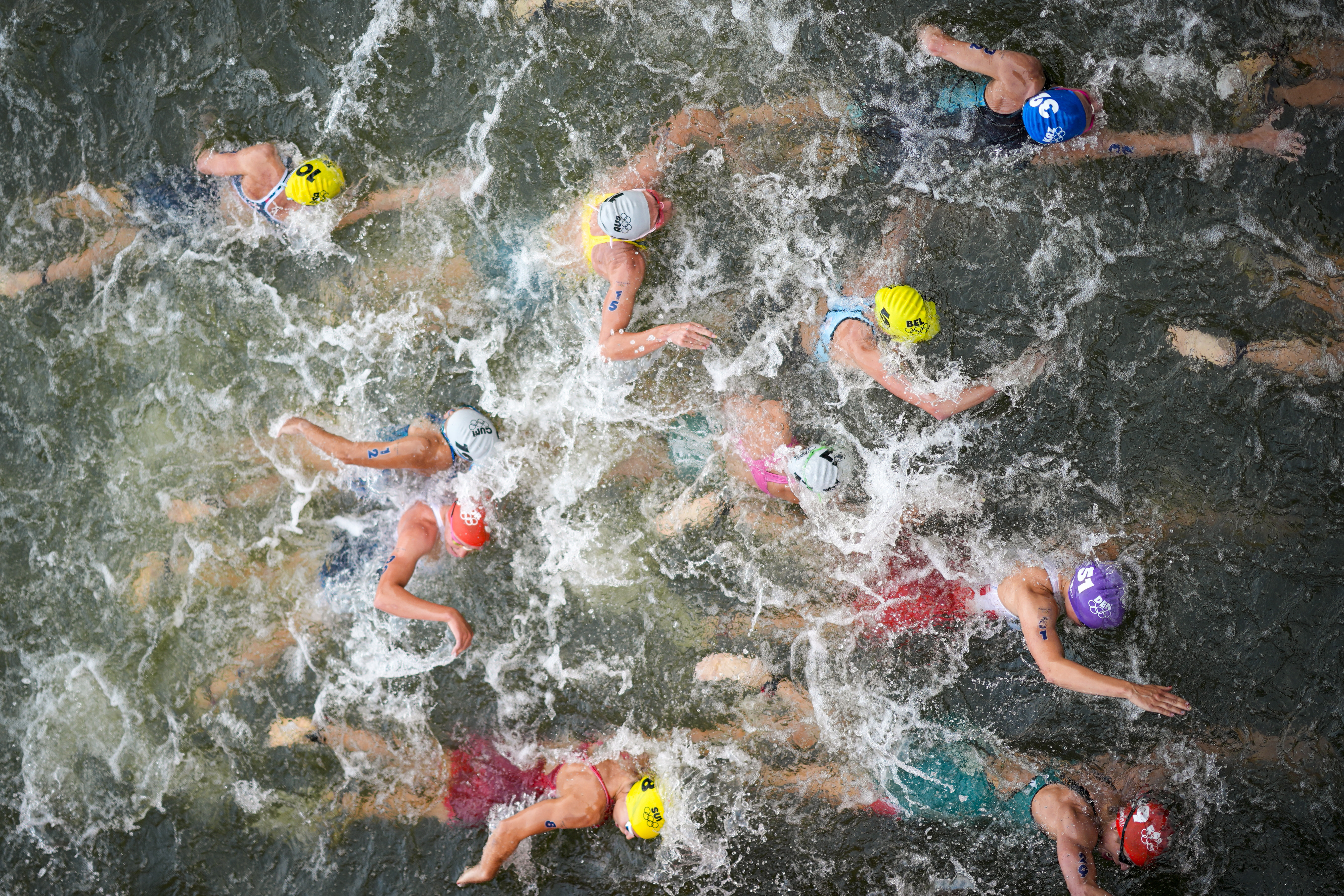 Australia's Natalie Van Coevorden, center, competes in the swim leg of the women's individual triathlon competition at the 2024 Summer Olympics, Wednesday, July 31, 2024, in Paris, France.