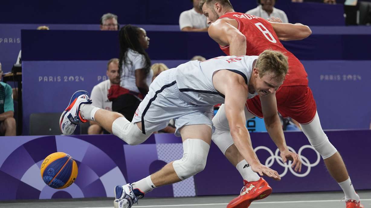 Poland's Przemyslaw Zamojski, right, fouls Canyon Barry of the United States in the men's 3x3 basketball pool round match between the United States and Poland at the 2024 Summer Olympics, Wednesday, July 31, 2024, in Paris, France.
