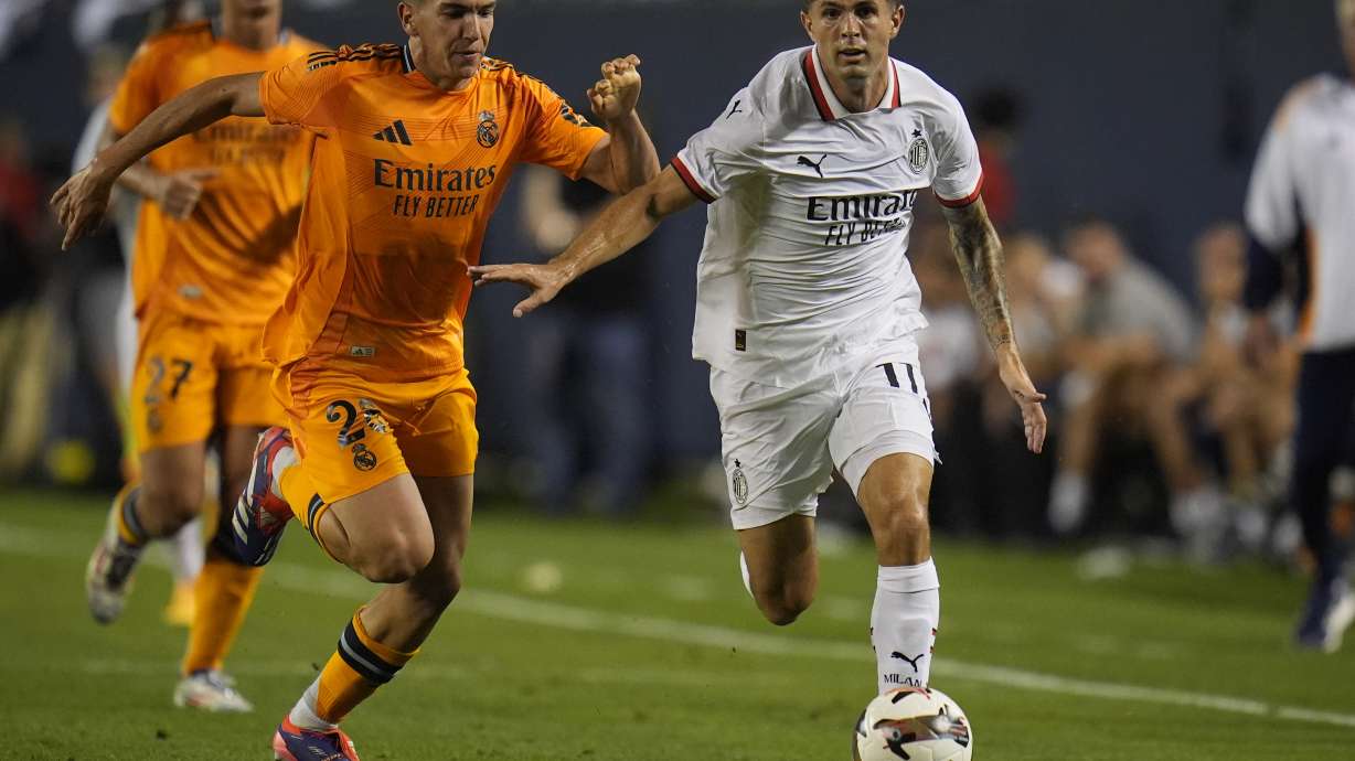 Real Madrid midfielder Mario MartÃn, left, and Milan forward Christian Pulisic chase the ball during the second half of a friendly soccer match Wednesday, July 31, 2024, in Chicago.