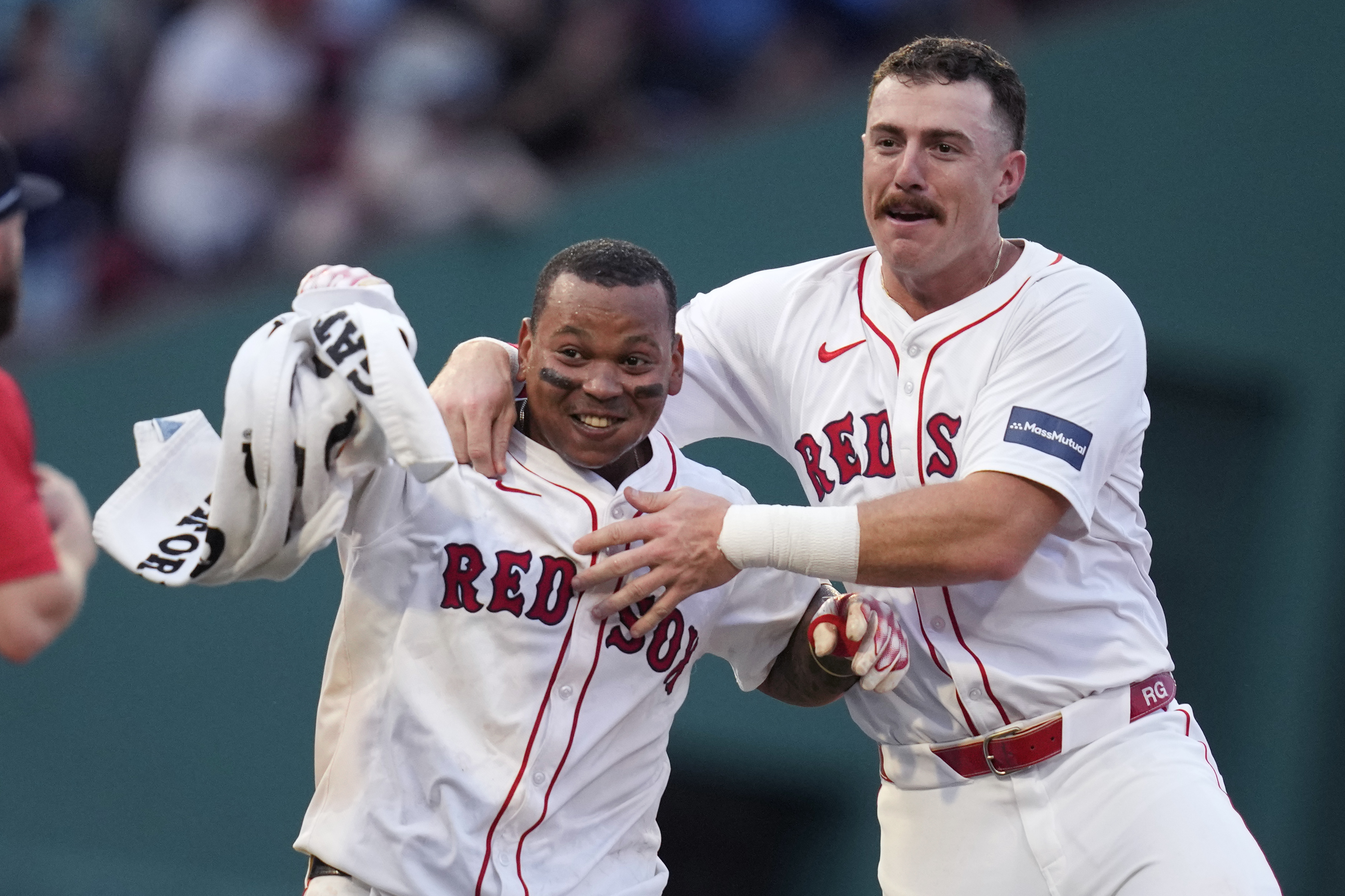Boston Red Sox's Rafael Devers, left, celebrates after his game-winning RBI double, which drove in Tyler O'Neill, during the 10th inning of a baseball game against the Seattle Mariners, Wednesday, July 31, 2024, in Boston. At right is Boston Red Sox shortstop Romy Gonzalez. 