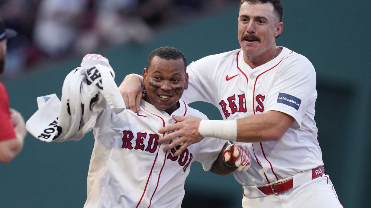 Boston Red Sox's Rafael Devers, left, celebrates after his game-winning RBI double, which drove in Tyler O'Neill, during the 10th inning of a baseball game against the Seattle Mariners, Wednesday, July 31, 2024, in Boston. At right is Boston Red Sox shortstop Romy Gonzalez.
