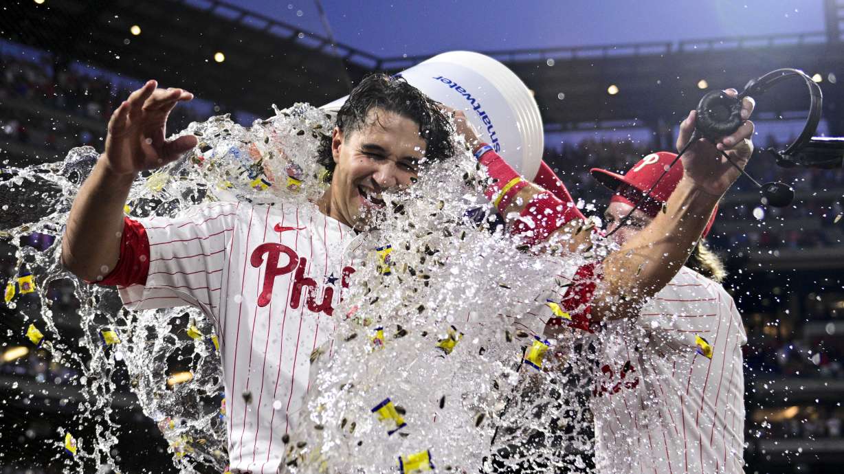 Philadelphia Phillies' Tyler Phillips, left, is doused by Brandon Marsh and Bryson Stott, right, after their victory over the Cleveland Guardians, Saturday, July 27, 2024, in Philadelphia.
