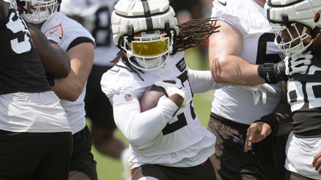 Cleveland Browns running back D'Onta Foreman, ceenter, cuts between two blockers during an NFL football training camp practice Friday, July 26, 2024, in White Sulphur Springs, W.Va.