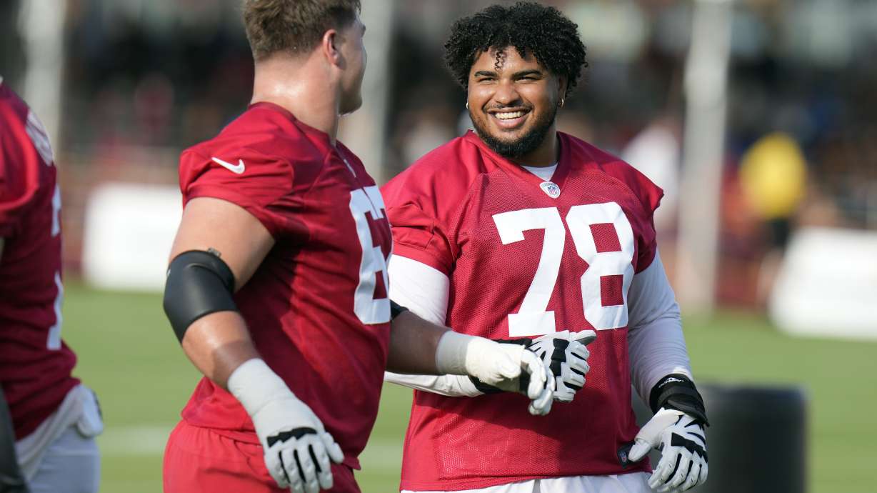 Tampa Bay Buccaneers tackle Tristan Wirfs (78) laughs with fellow tackle Luke Goedeke during an NFL football training camp practice Wednesday, July 24, 2024, in Tampa, Fla.