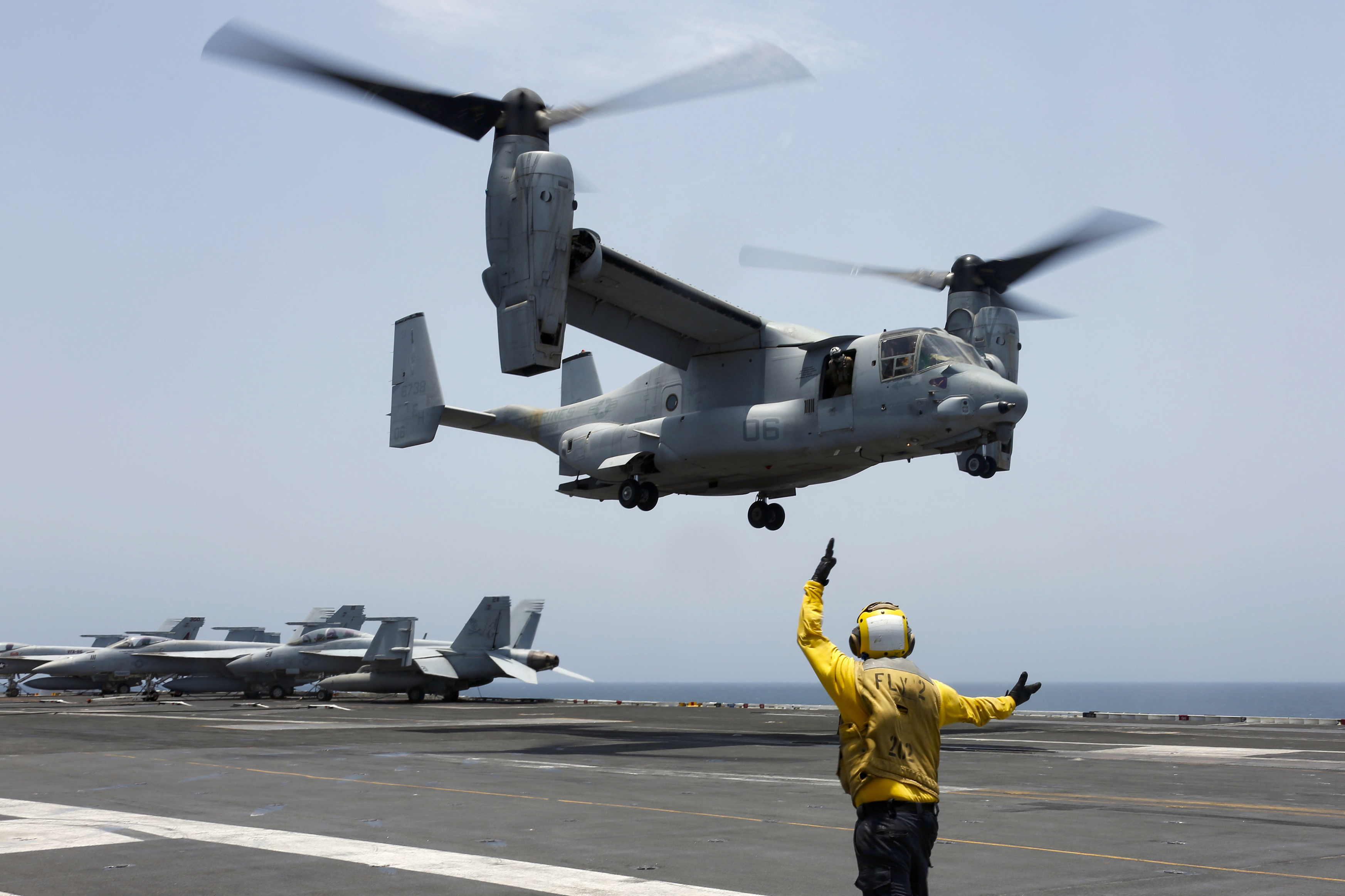 Aviation Boatswain's Mate 2nd Class Nicholas Hawkins signals an MV-22 Osprey to land on the flight deck of the USS Abraham Lincoln in the Arabian Sea on May 17, 2019. 