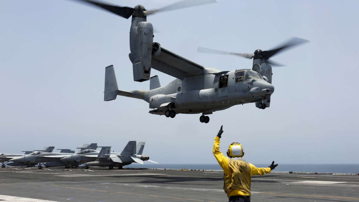 Aviation Boatswain's Mate 2nd Class Nicholas Hawkins signals an MV-22 Osprey to land on the flight deck of the USS Abraham Lincoln in the Arabian Sea on May 17, 2019.