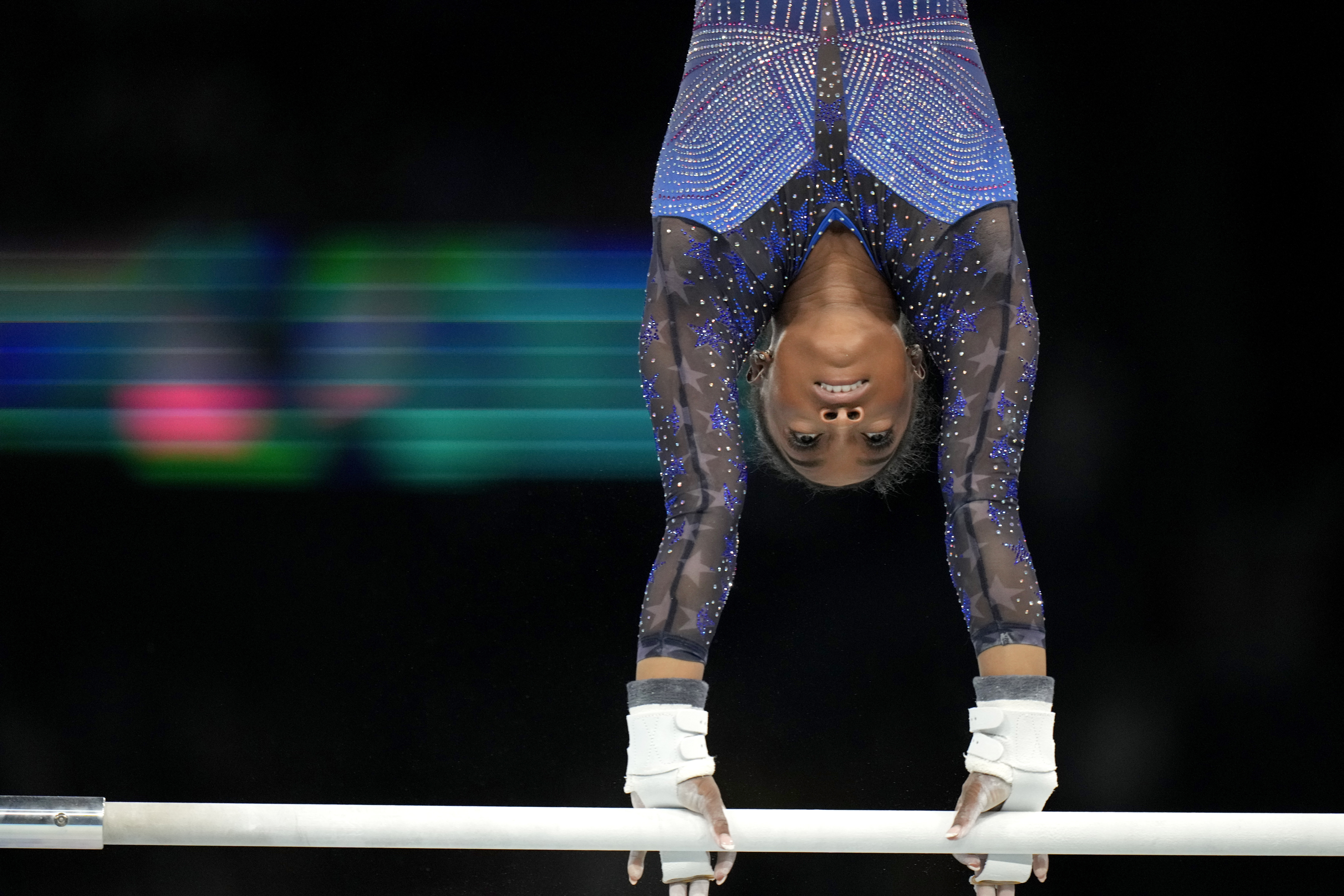 Simone Biles, of the United States, warms up on uneven bars during the women's artistic gymnastics all-around finals in Bercy Arena at the 2024 Summer Olympics, Thursday, Aug. 1, 2024, in Paris, France. 