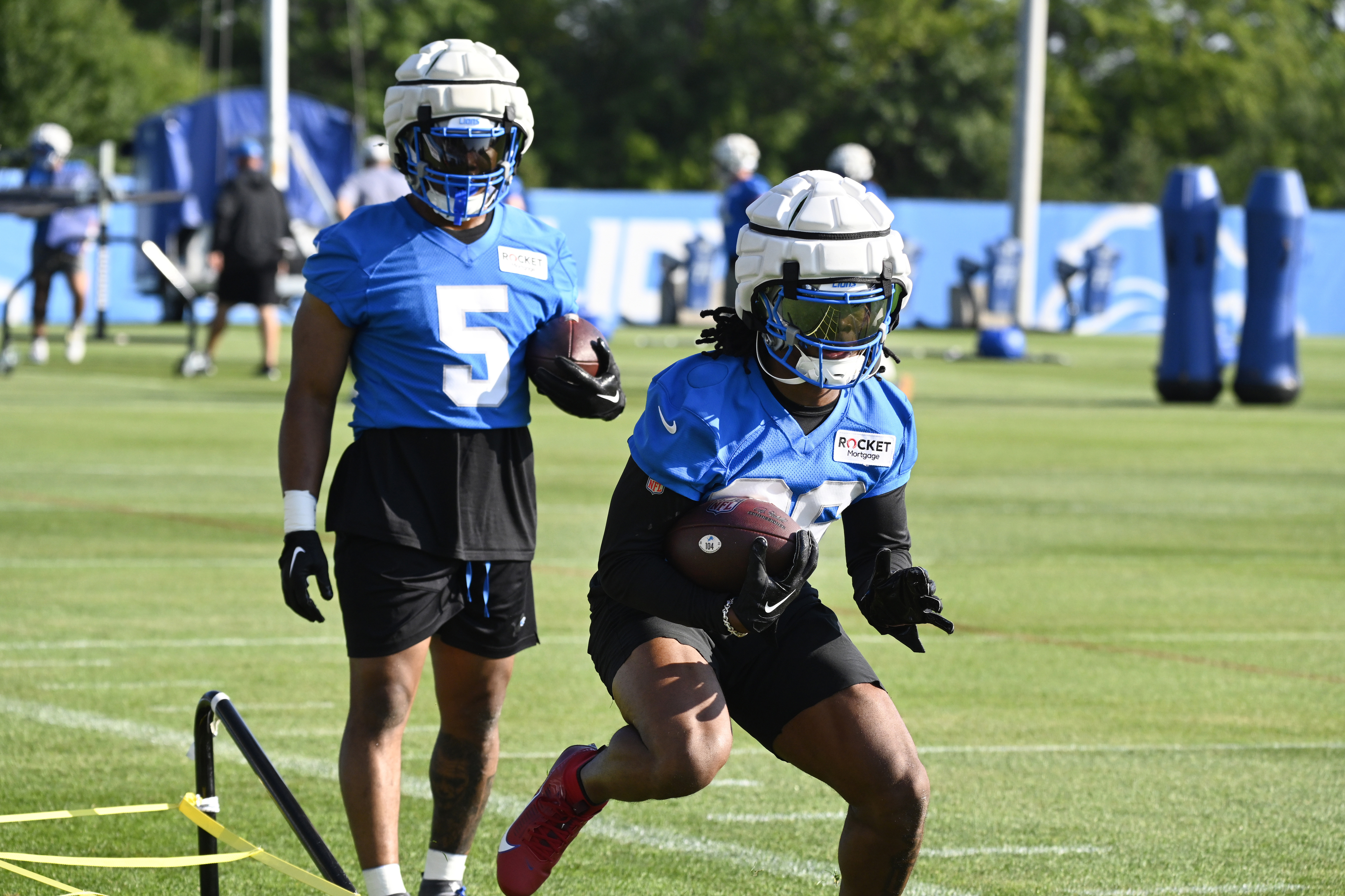 Detroit Lions running back Jahmyr Gibbs, front, runs a drill as David Montgomery looks on during an NFL football practice in Allen Park, Mich., Saturday, July 27, 2024. 