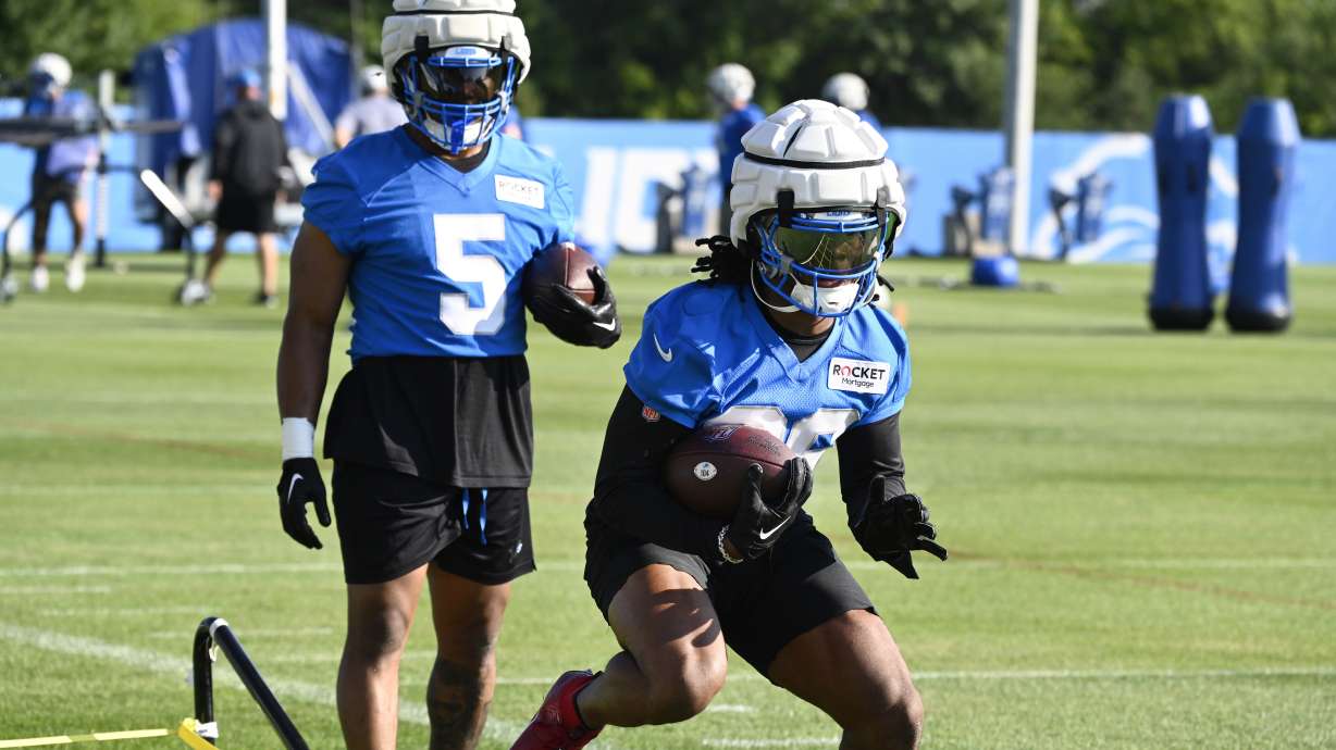 Detroit Lions running back Jahmyr Gibbs, front, runs a drill as David Montgomery looks on during an NFL football practice in Allen Park, Mich., Saturday, July 27, 2024.
