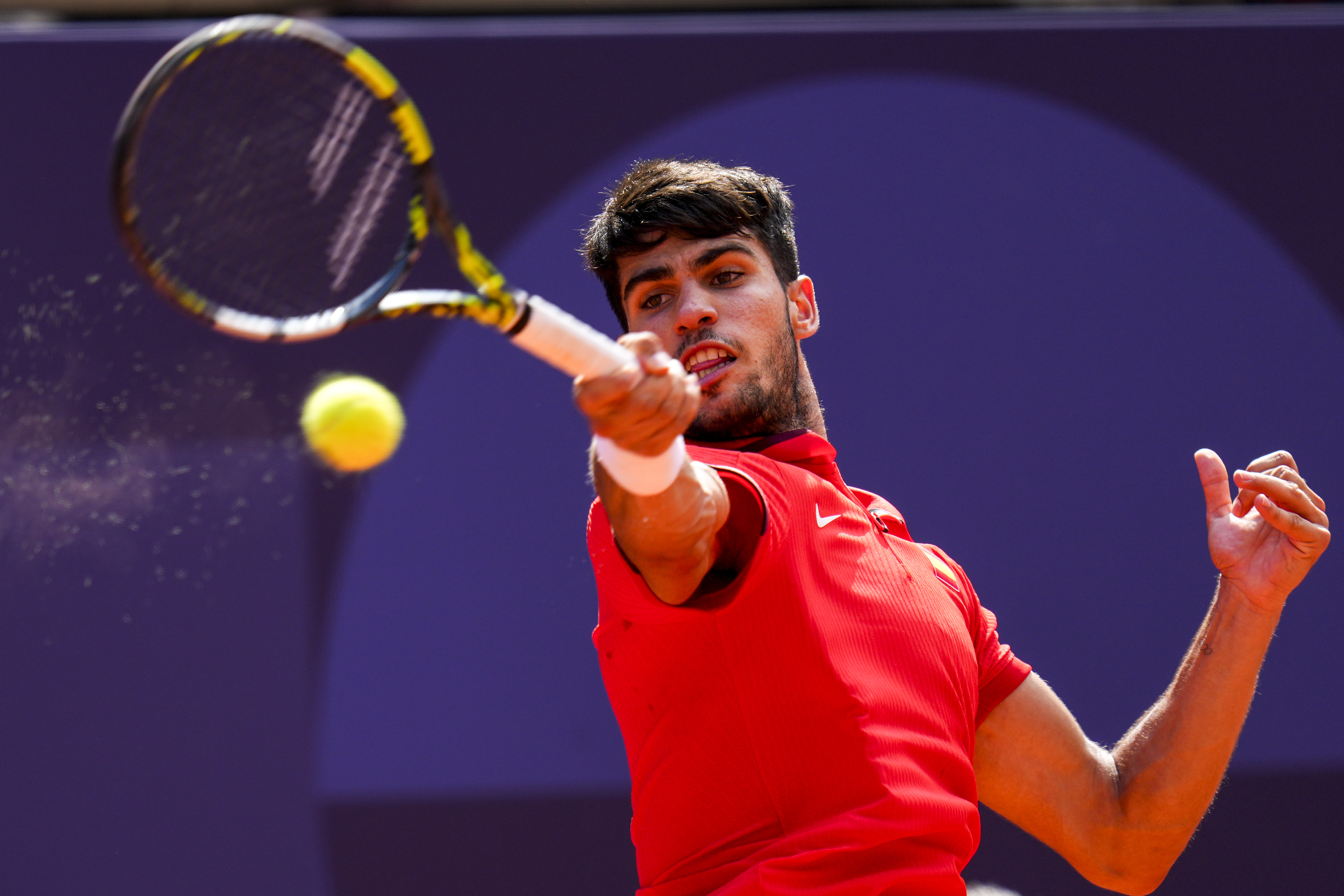 Carlos Alcaraz of Spain returns the ball against Tommy Paul, of United States during their men's quarter-final match at the Roland Garros stadium, at the 2024 Summer Olympics, Thursday, Aug. 1, 2024, in Paris, France. 