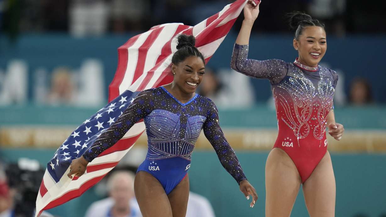 Simone Biles, left, celebrates with teammate Suni Lee, of the United States, after winning the gold and bronze medals respectively in the women's artistic gymnastics all-around finals in Bercy Arena at the 2024 Summer Olympics, Thursday, Aug. 1, 2024, in Paris, France.