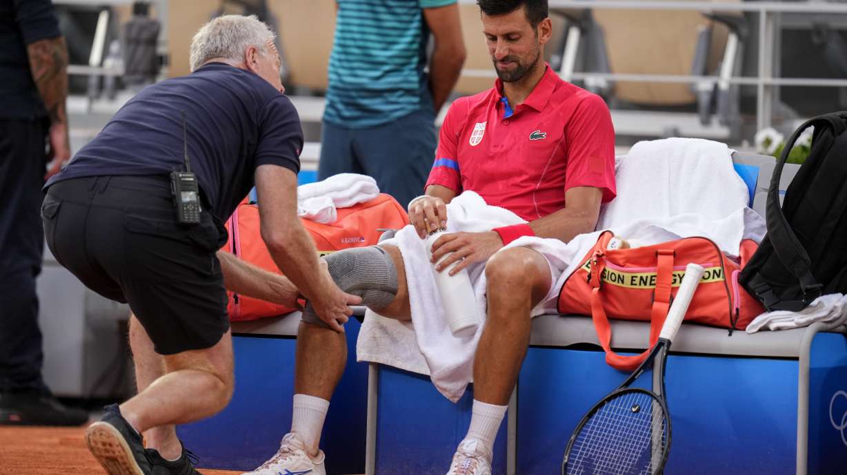 Serbia's Novak Djokovic receives medical treatment during his match against against Stefanos Tsitsipas of Greece during their men's quarter-final match at the Roland Garros stadium, at the 2024 Summer Olympics, Thursday, Aug. 1, 2024, in Paris, France.