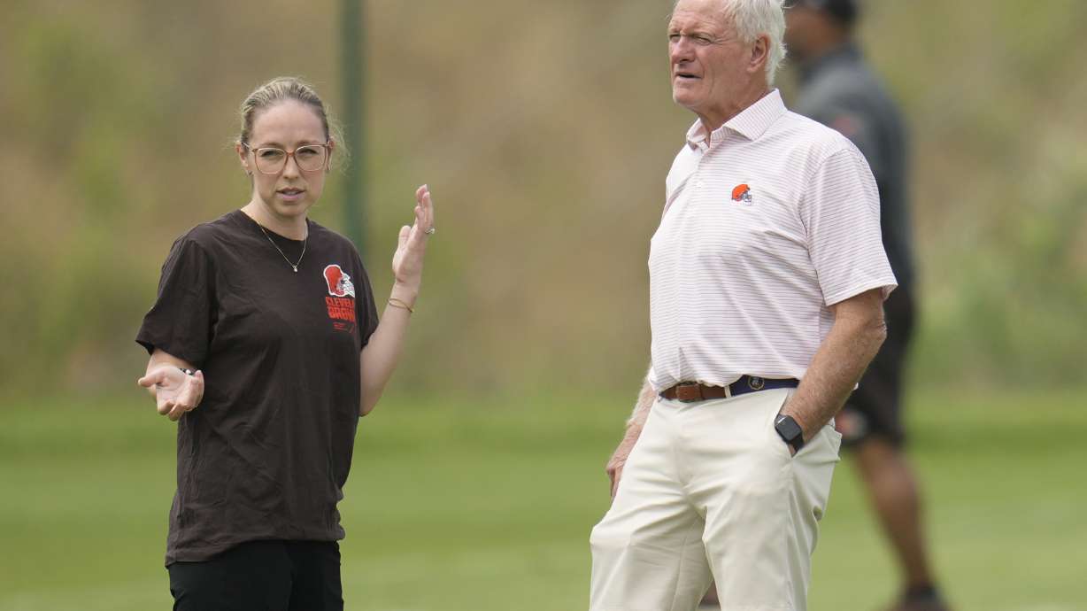 Cleveland Browns owner Jimmy Haslam, right, talks with Catherine Raiche, left, assistant general manager and vice president of football operations, during an NFL football training camp practice Saturday, July 27, 2024, in White Sulphur Springs, W.Va.