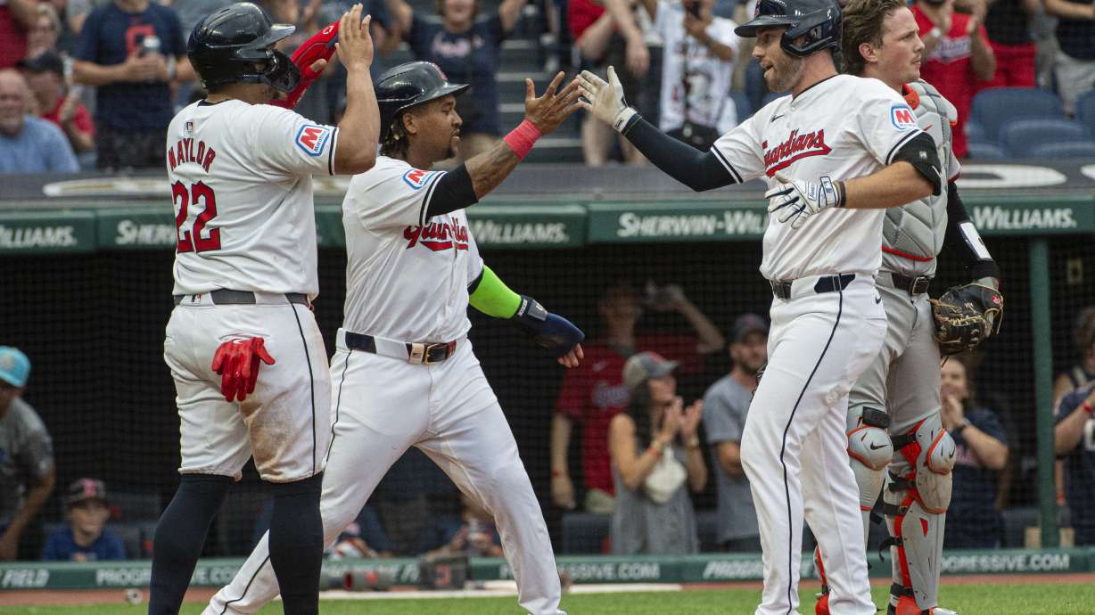 Cleveland Guardians' Josh Naylor (22) and Jose Ramirez, second from left, congratulate David Fry, front right, after Fry's three-run home run off Baltimore Orioles starting pitcher Trevor Rogers as Orioles catcher Adley Rutschman, back right, stands behind during the third inning of a baseball game in Cleveland, Thursday, Aug. 1, 2024.