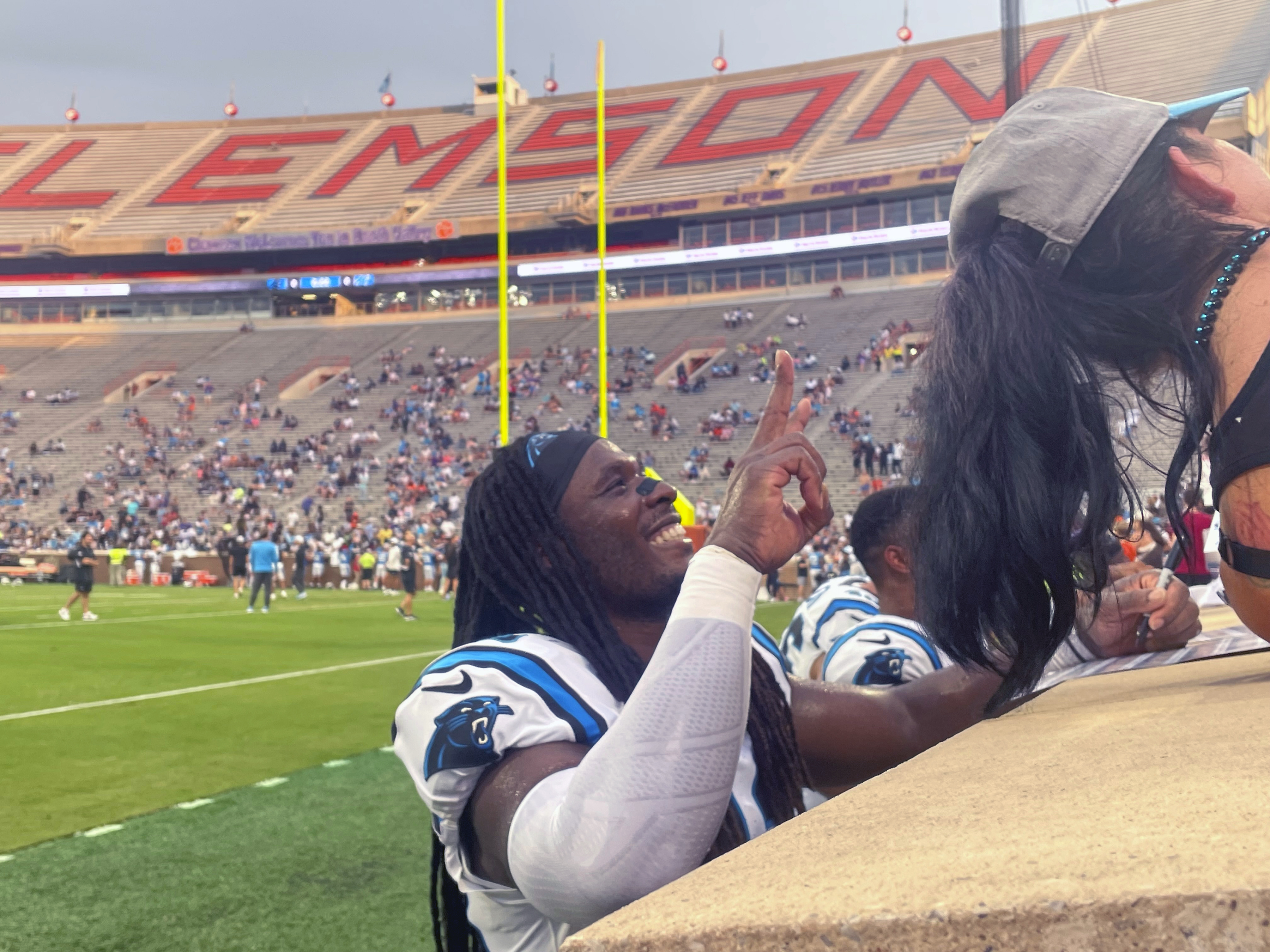 Carolina Panthers outside linebacker Luigi Vilain, left, gives autographs at the team's Fan Fest NFL football practice at Clemson's Memorial Stadium, Thursday, Aug. 1, 2024, in Clemson, S.C. The Panthers played their inaugural home games in 1995 at Clemson.