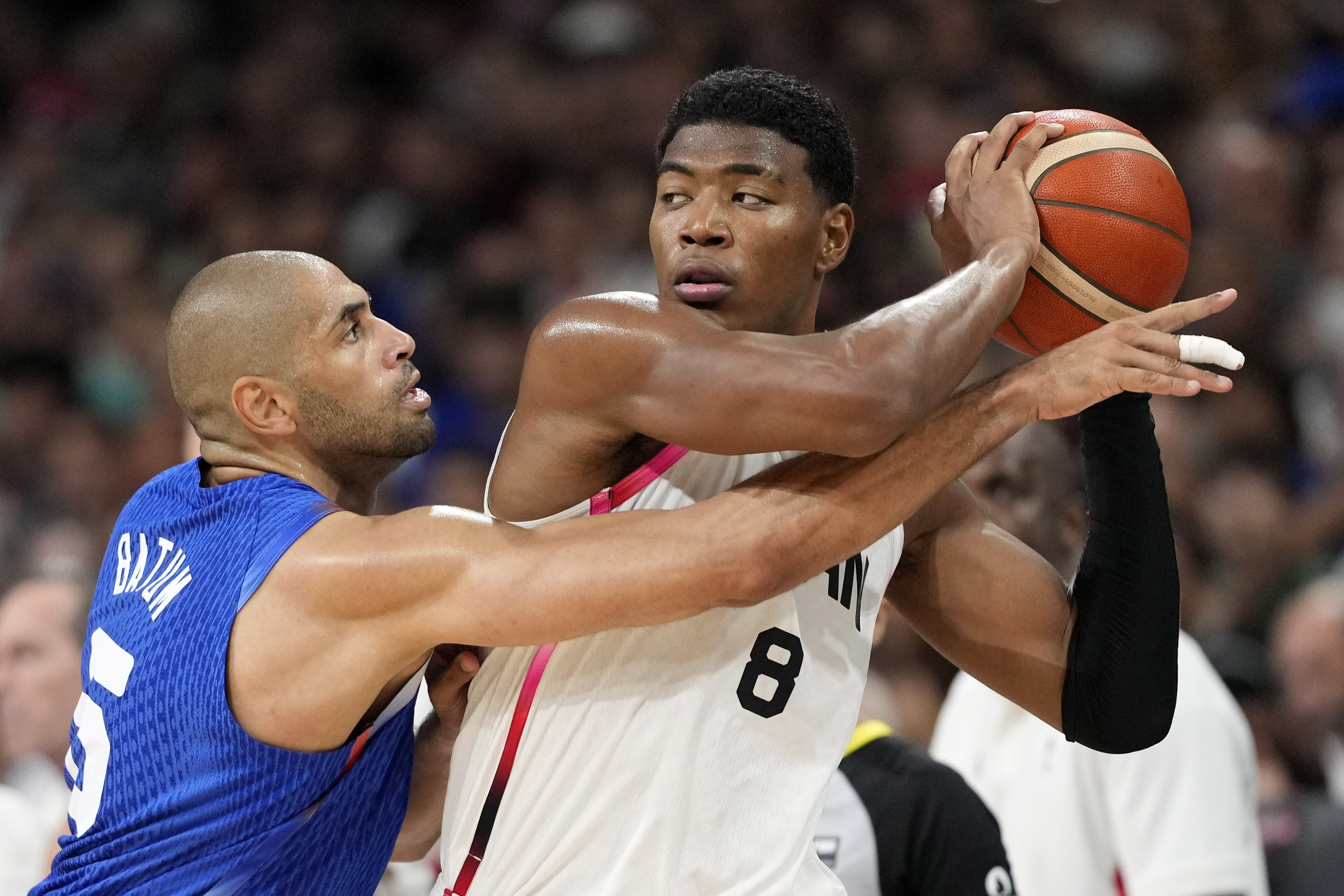 France's Nicolas Batum, left, reaches in on Japan's Rui Hachimura in a men's basketball game at the 2024 Summer Olympics, Tuesday, July 30, 2024, in Villeneuve-d'Ascq, France. 