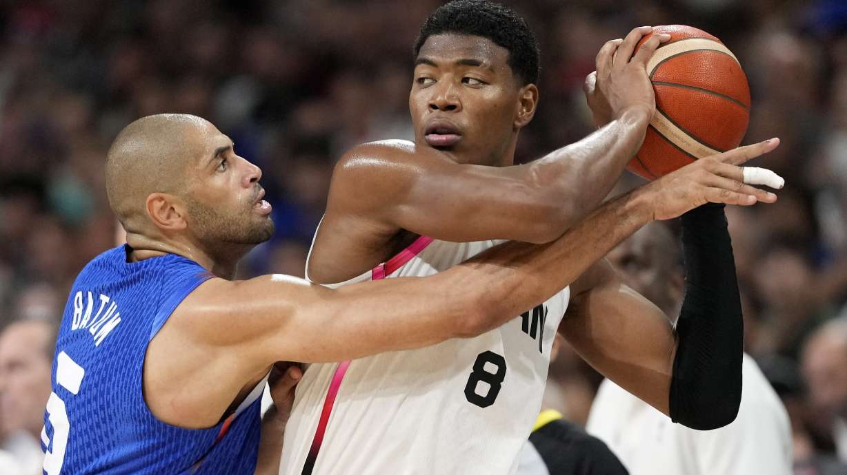 France's Nicolas Batum, left, reaches in on Japan's Rui Hachimura in a men's basketball game at the 2024 Summer Olympics, Tuesday, July 30, 2024, in Villeneuve-d'Ascq, France.