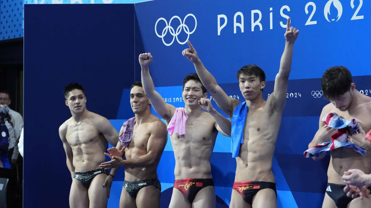 China's Long Daoyi and Wang Zongyuan celebrate after winning the gold medal in the men's synchronised 3m springboard diving final at the 2024 Summer Olympics, Friday, Aug. 2, 2024, in Saint-Denis, France.
