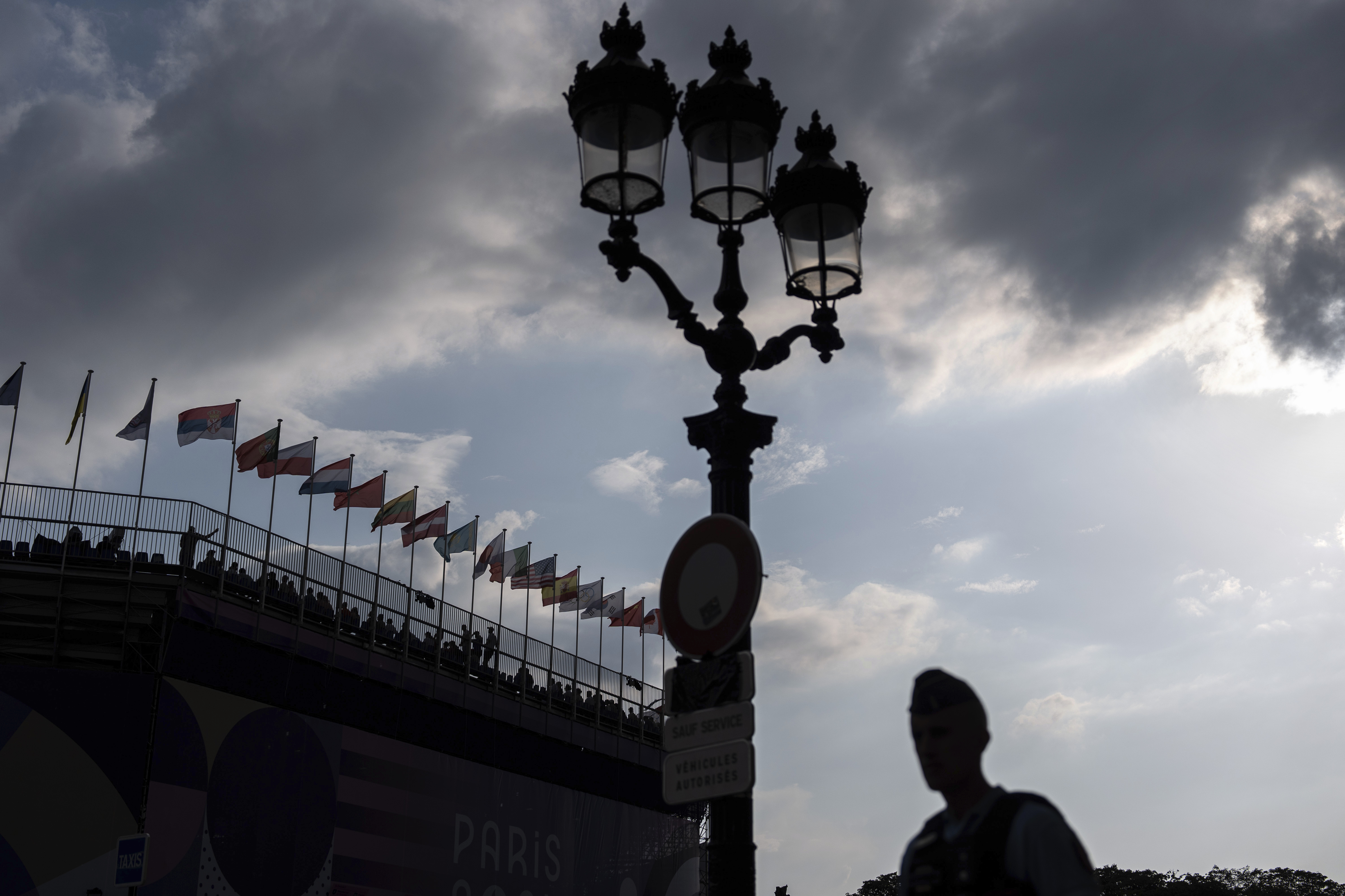 A police officer patrols outside the venue as spectators watch a 3x3 basketball game from the stands at the 2024 Summer Olympics, Thursday, Aug. 1, 2024, in Paris, France. 