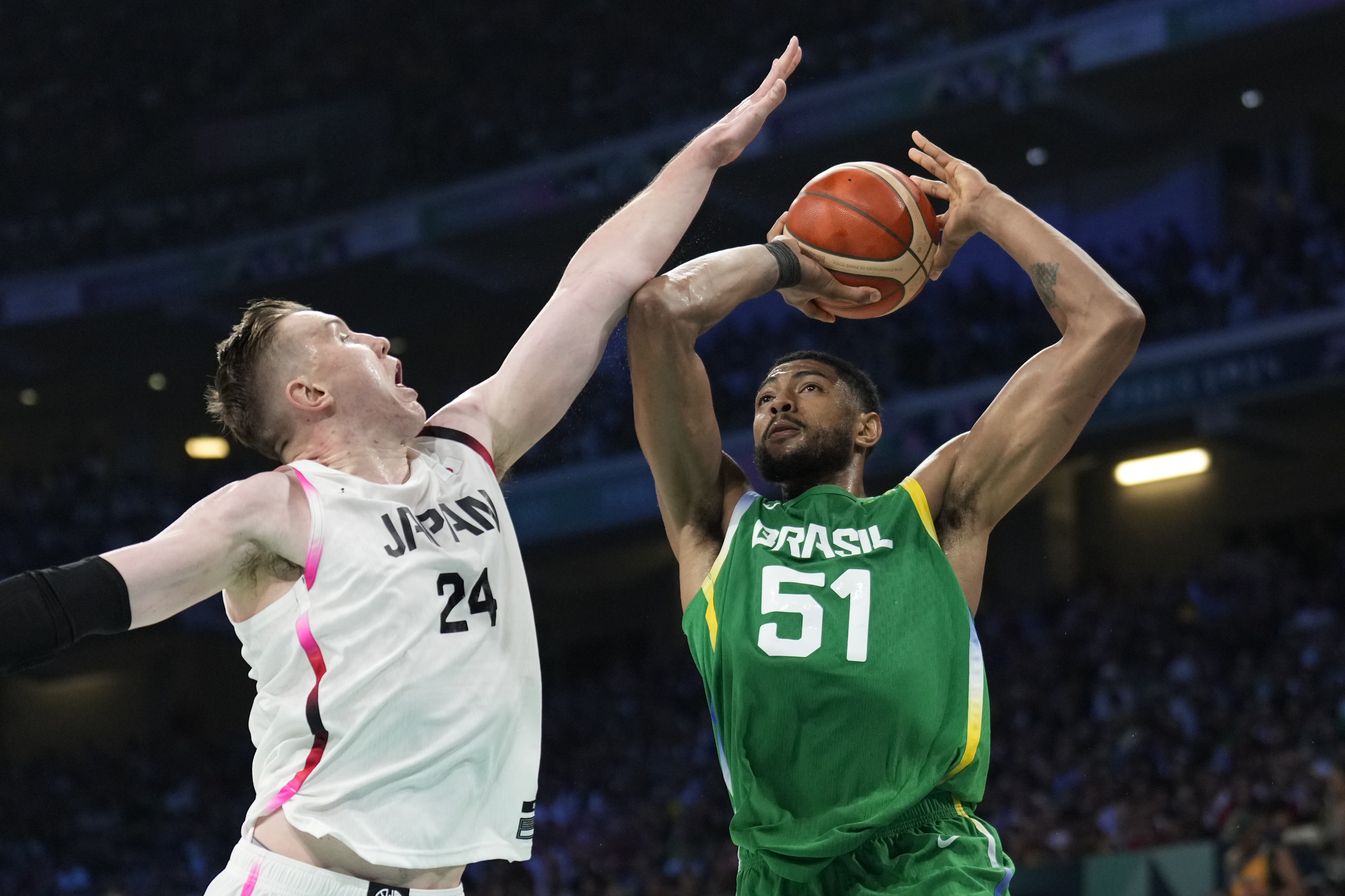 Bruno Caboclo, of Brazil, shoots over Josh Hawkinson, of Japan, in a men's basketball game at the 2024 Summer Olympics, Friday, Aug. 2, 2024, in Villeneuve-d'Ascq, France. 