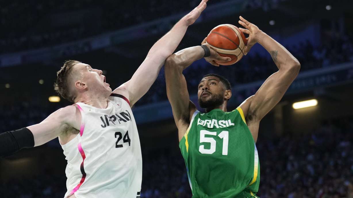 Bruno Caboclo, of Brazil, shoots over Josh Hawkinson, of Japan, in a men's basketball game at the 2024 Summer Olympics, Friday, Aug. 2, 2024, in Villeneuve-d'Ascq, France.