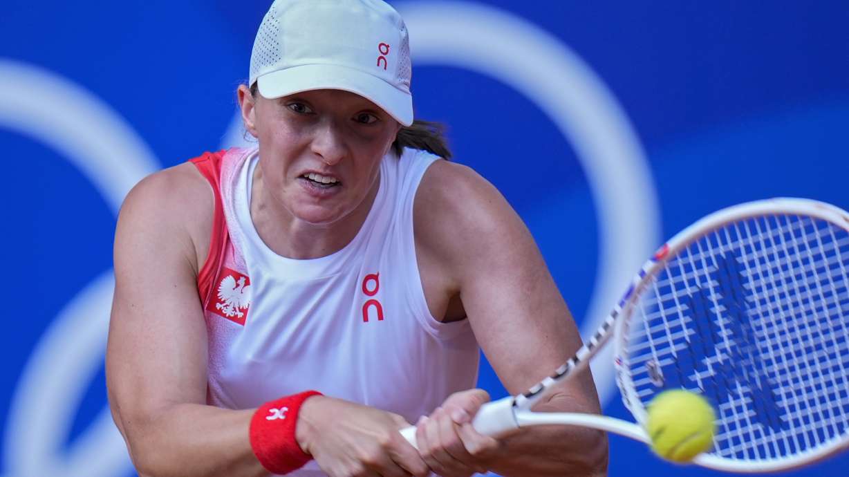 Iga Swiatek of Poland returns a shot to Anna Karolina Schmiedlova of Slovakia during their women's bronze medal match, at the 2024 Summer Olympics, Friday, Aug. 2, 2024, at the Roland Garros stadium in Paris, France.