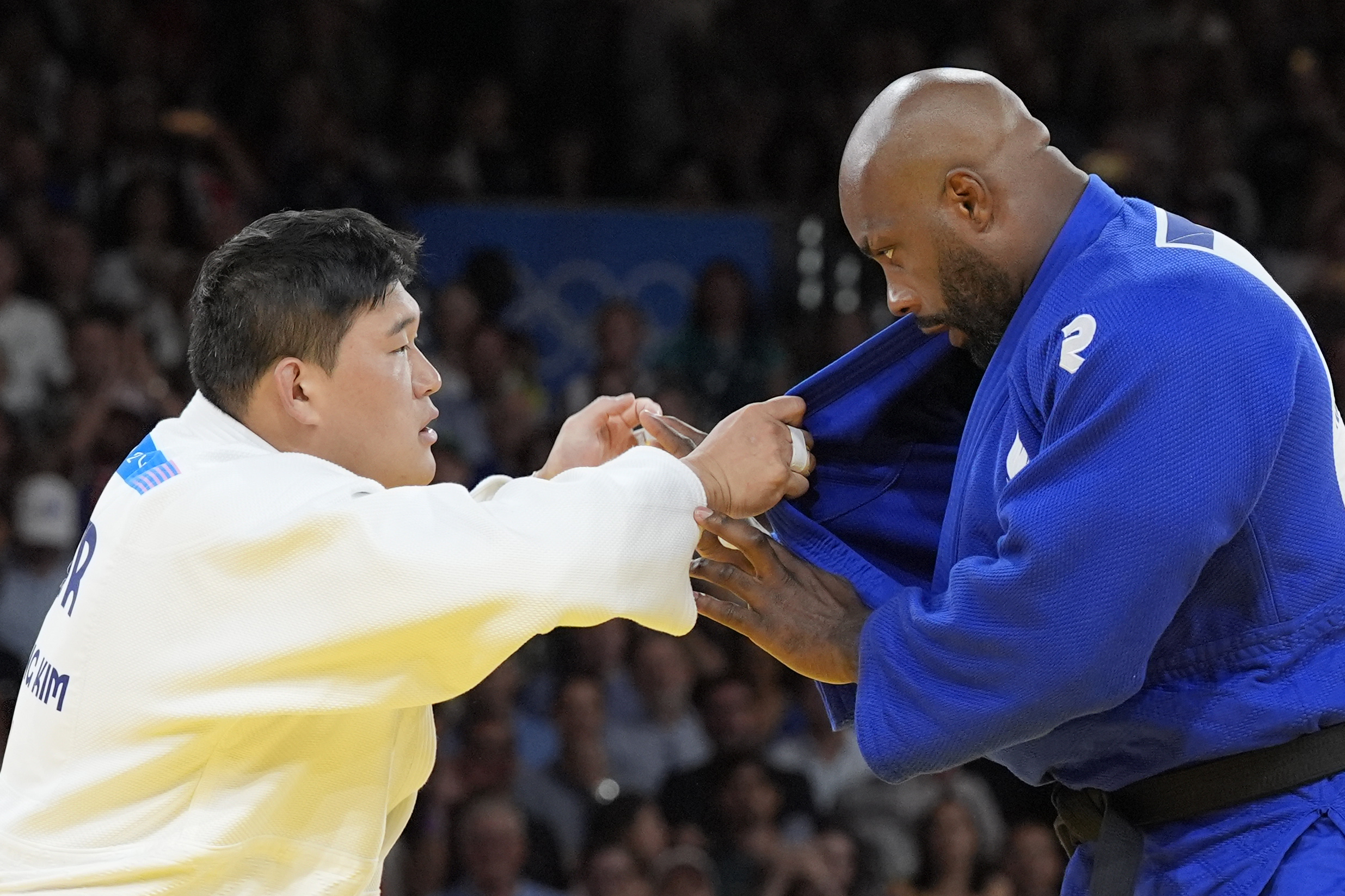 South Korea's Min-Jong Kim and France's Teddy Riner compete during their men's +100 kg final match in the team judo competition, at Champ-de-Mars Arena, during the 2024 Summer Olympics, Friday, Aug. 2, 2024, in Paris, France.