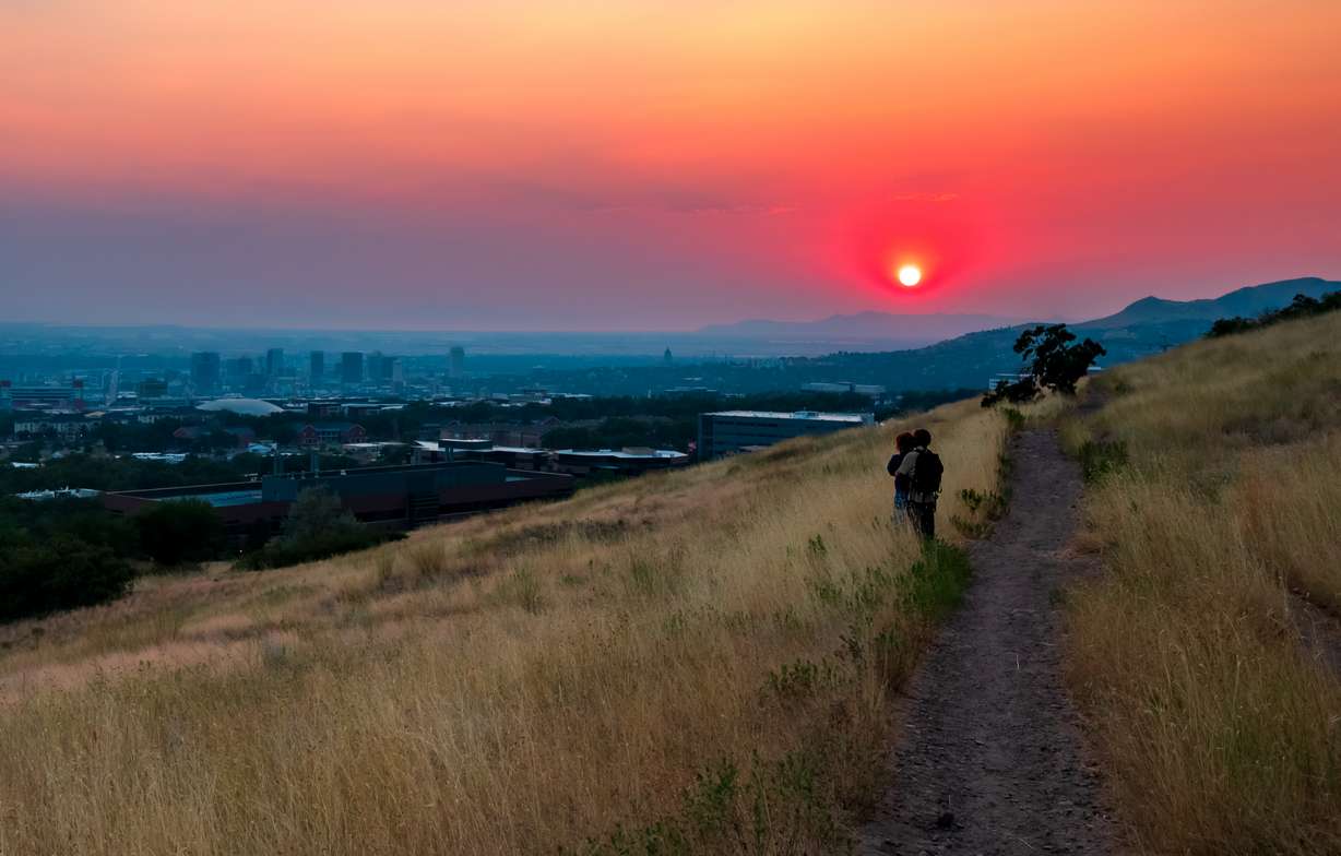 Hikers watch a smoky sunset from the Bonneville Shoreline Trail near the University of Utah in Salt Lake City on Sunday. Smoke from fires west of Utah has been a fixture across the Wasatch Front this week.