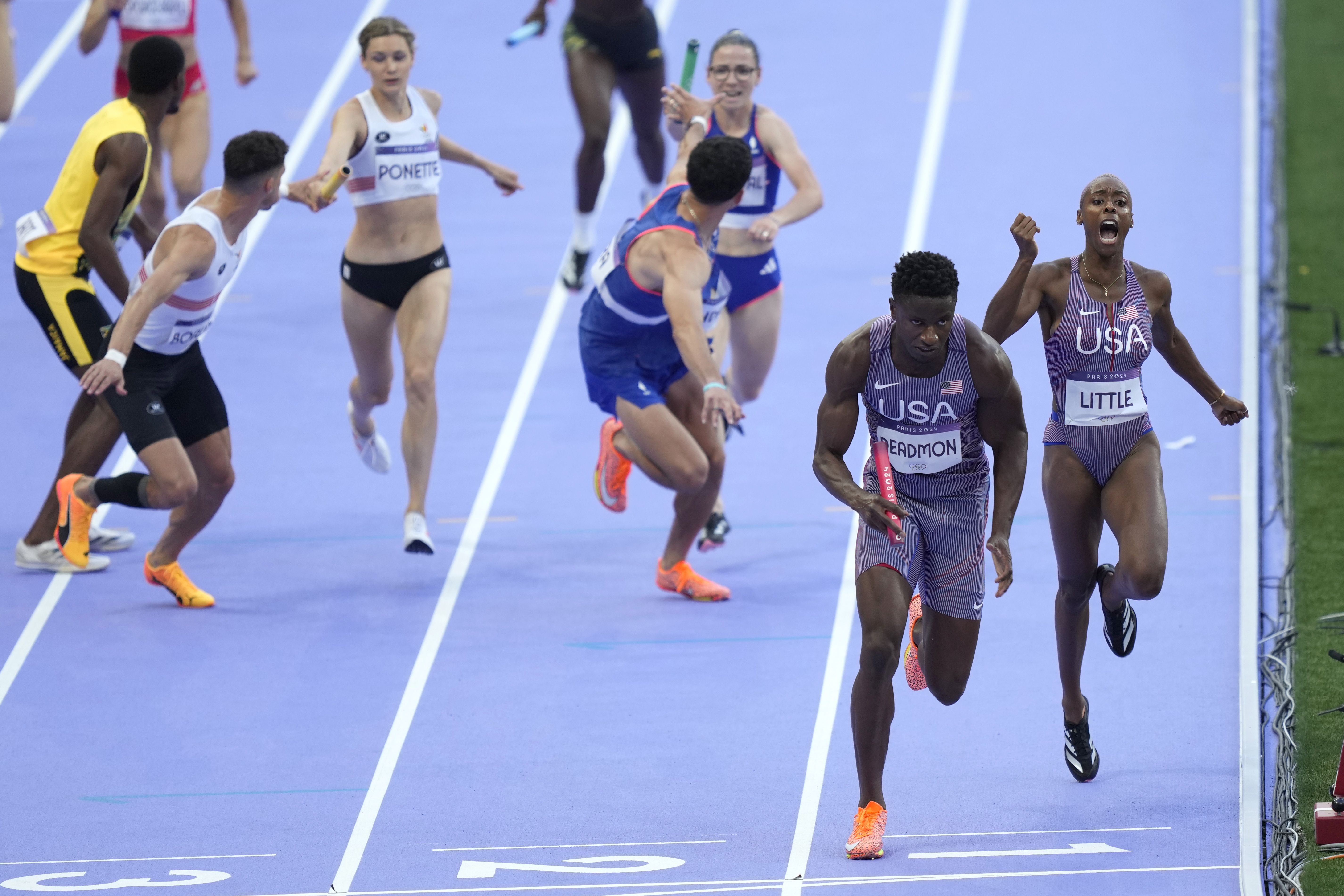 Shamier Little hands off to Bryce Deadmon, of the United States, during a heat in the 4 x 400-meter relay mixed at the 2024 Summer Olympics, Friday, Aug. 2, 2024, in Saint-Denis, France. 