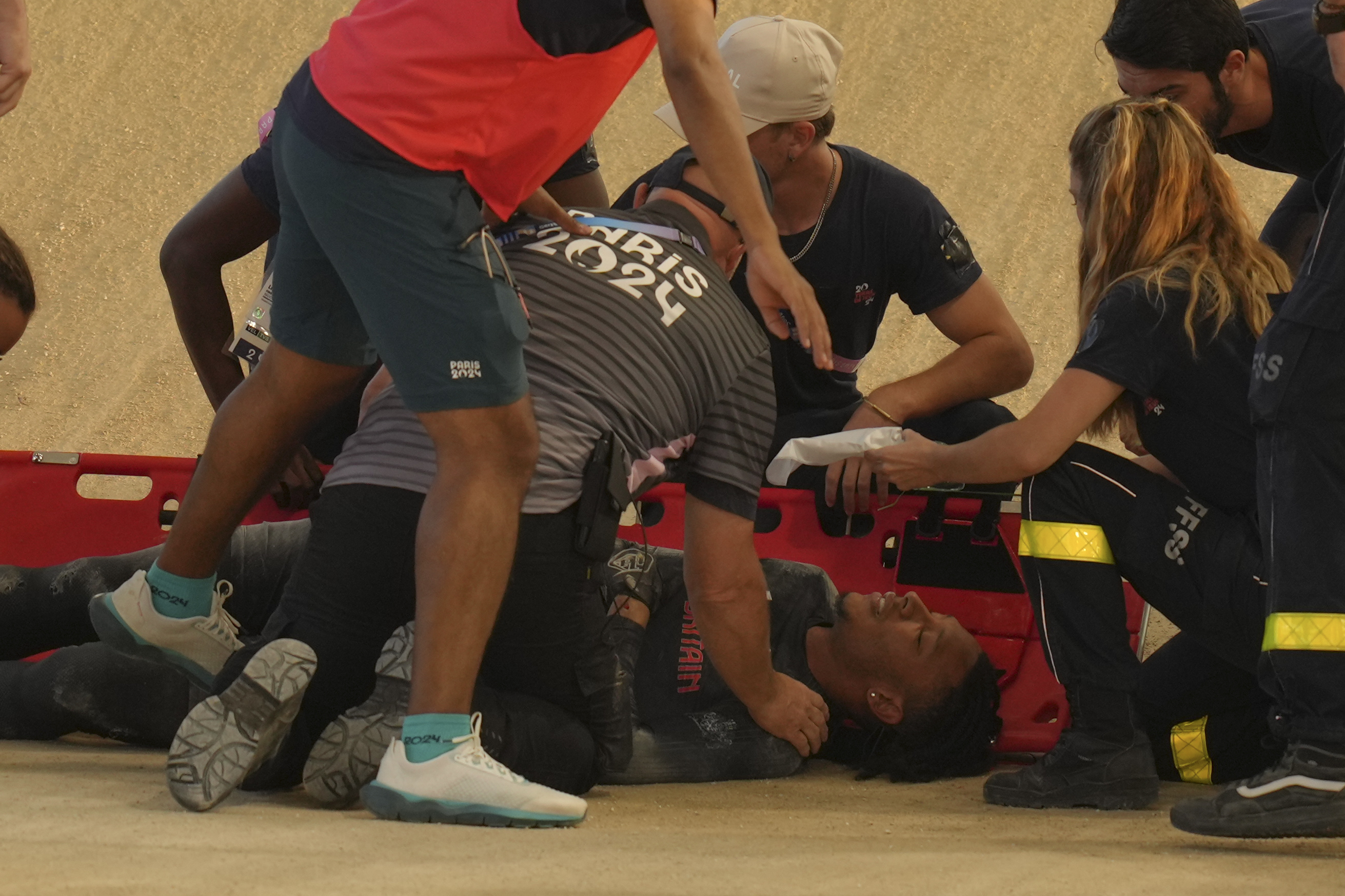 Kye Whyte of Britain receives medical assistance after crashing during a BMX racing event, at the 2024 Summer Olympics, Friday, Aug. 2, 2024, in Saint-Quentin-en-Yvelines, France.