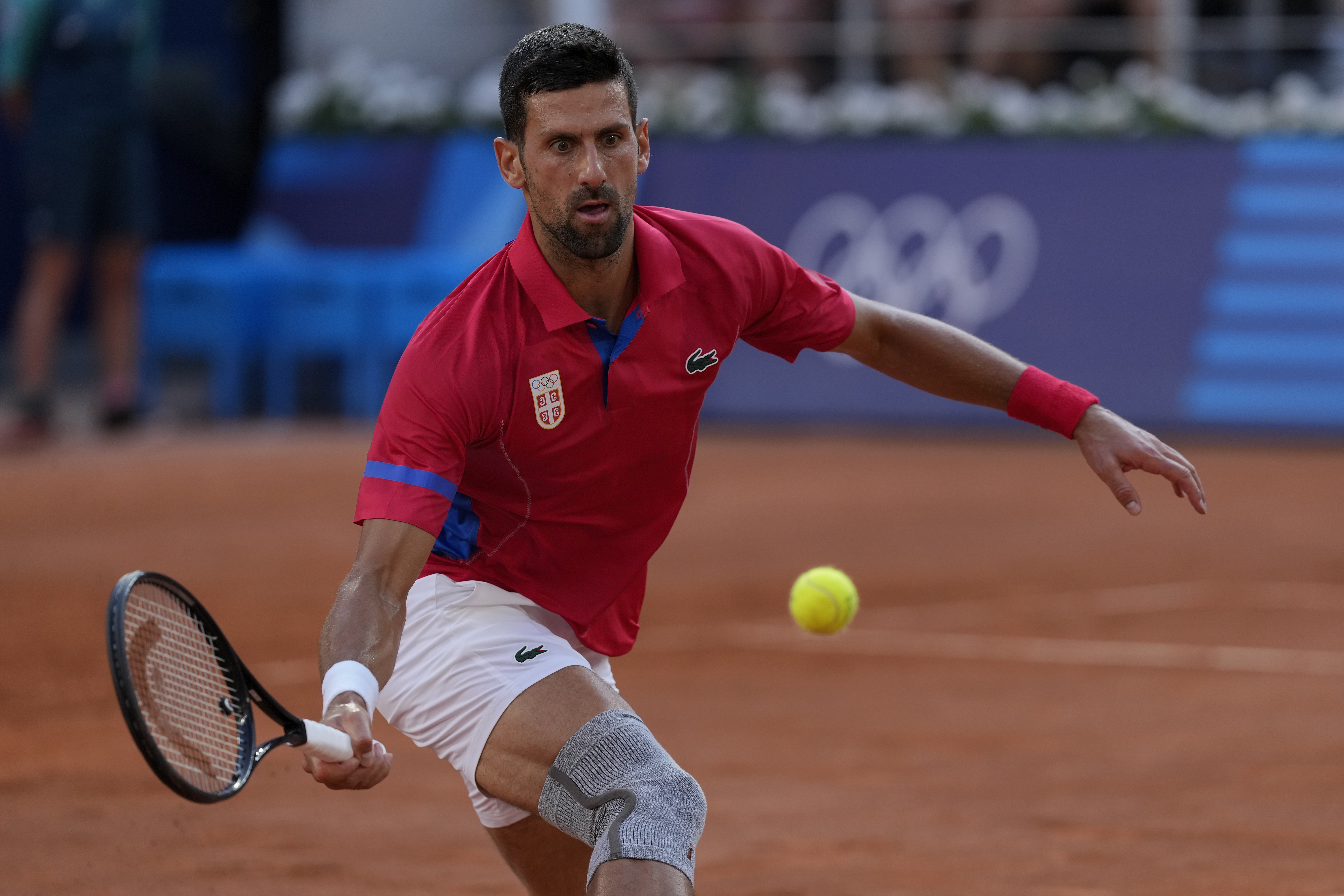 Novak Djokovic of Serbia returns a shot to Lorenzo Musetti of Italy during their men's singles semifinals tennis match, at the 2024 Summer Olympics, Friday, Aug. 2, 2024, at the Roland Garros stadium in Paris, France. 