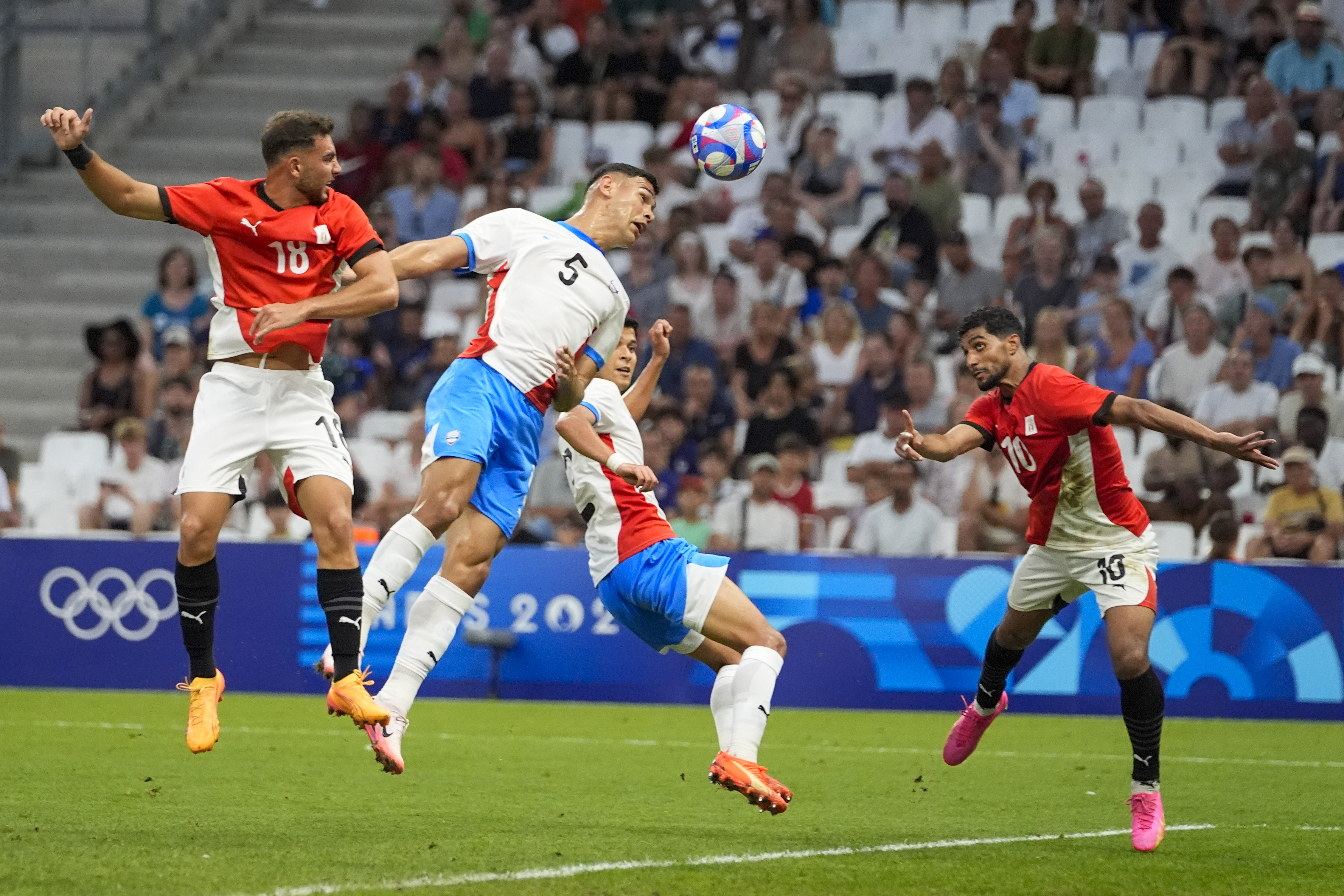 Paraguay's Gilberto Flores (5) is unable to deflect a cross as Egypt's Ibrahim Adel, right, prepares to head the ball in for a goal during a men's quarterfinal soccer match between Egypt and Paraguay at the 2024 Summer Olympics, Friday, Aug. 2, 2024, at Marseille Stadium in Marseille, France.