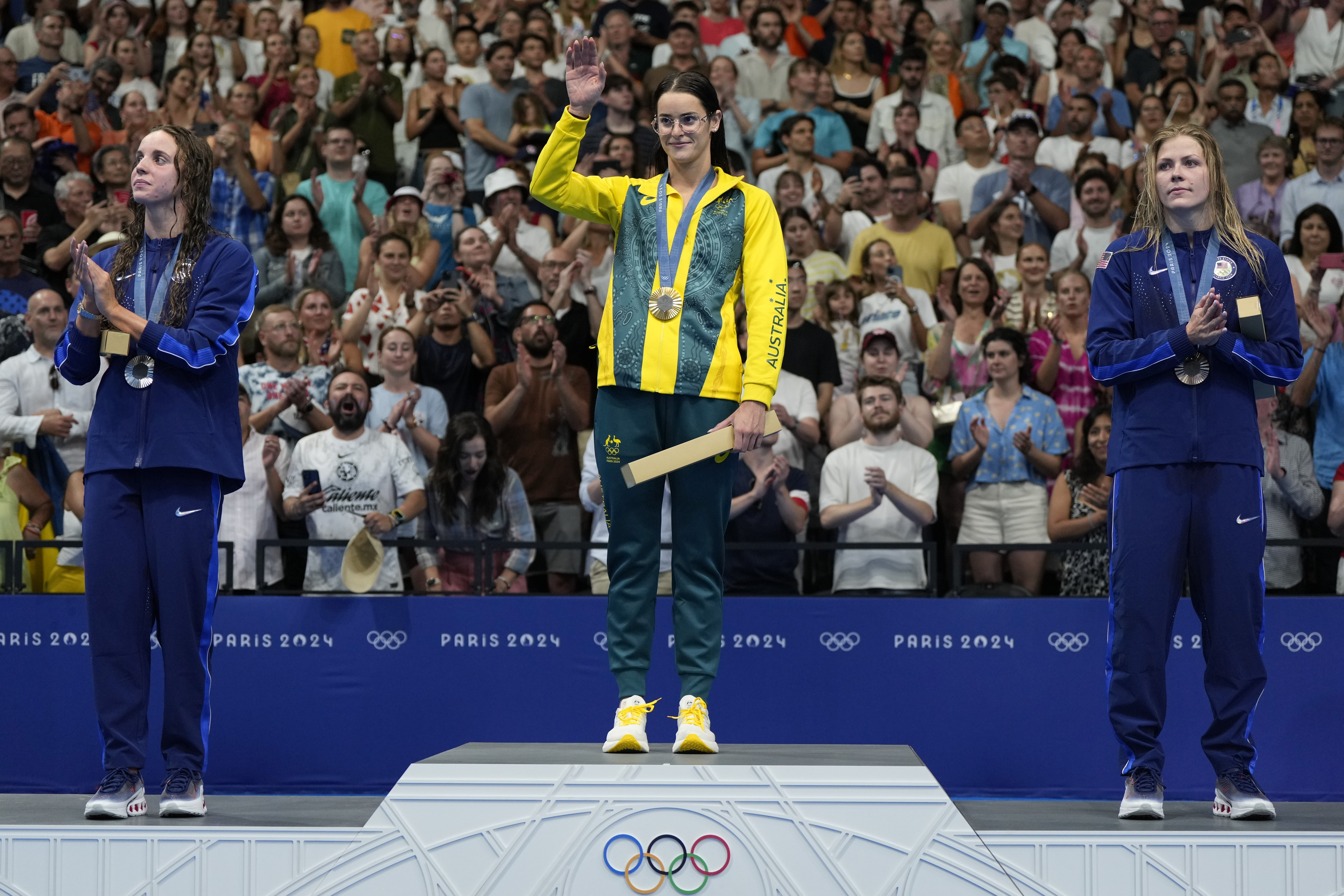 CAPTION CORRECTS SPELLING Gold medalist Australia's Kaylee McKeown, centre, stands with silver medalist, Regan Smith of the United States, left, and bronze medalist Katharine Berkoff of the United States on the podium following women's 100-meter backstroke final at the 2024 Summer Olympics, Monday, Tuesday, July 30, 2024. 